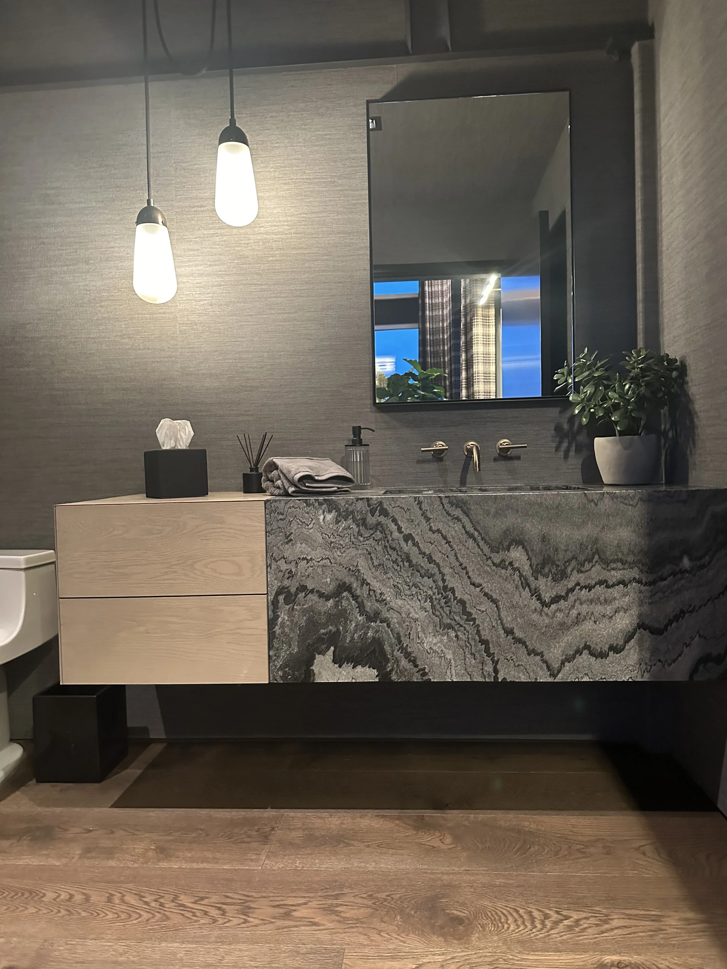 Modern executive bathroom with marble-textured vanity, minimalist lighting, and luxury finishes