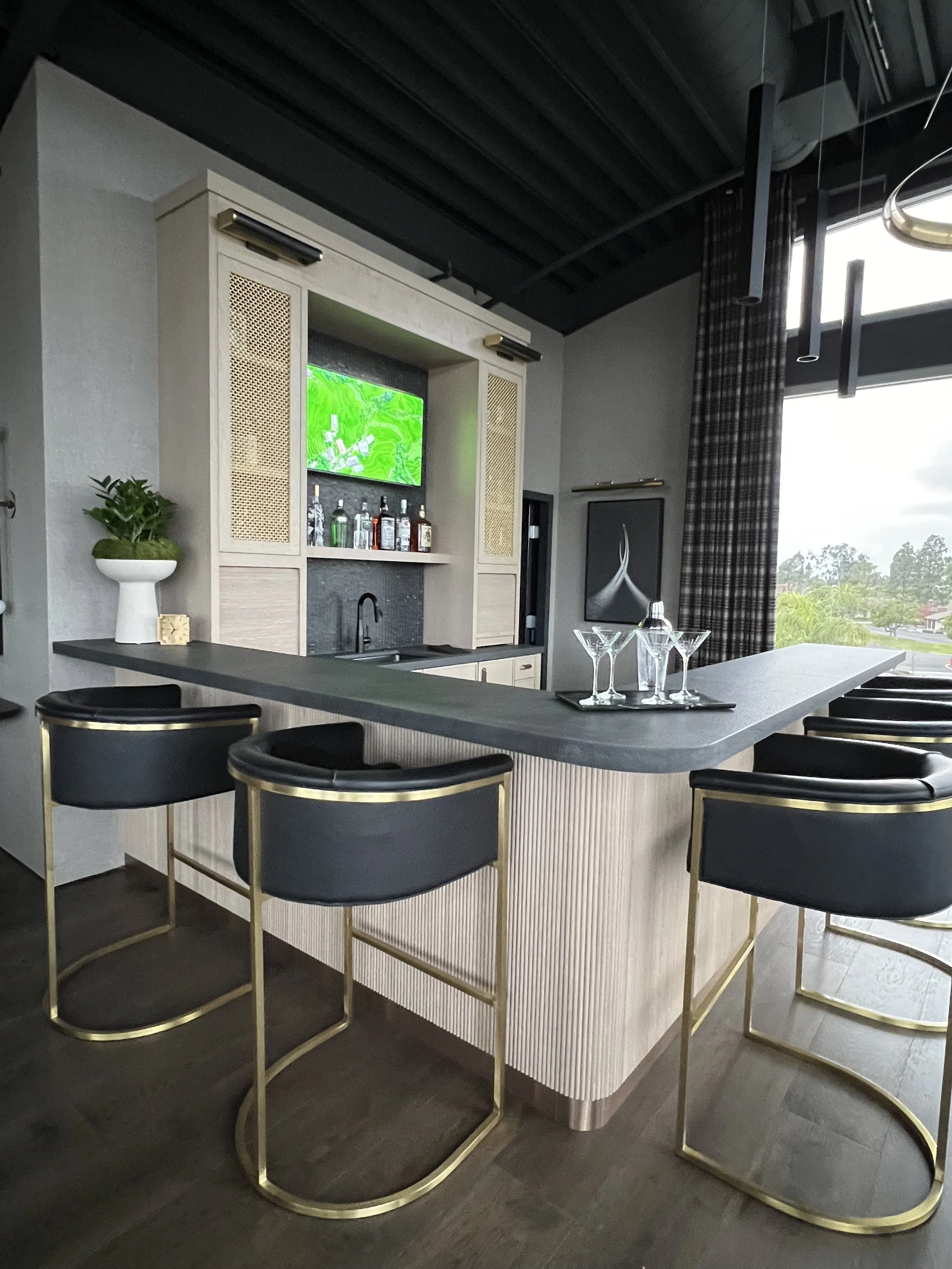 High-end CEO office bar with liquor display, dark counters, and built-in aquarium accent in modern workspace