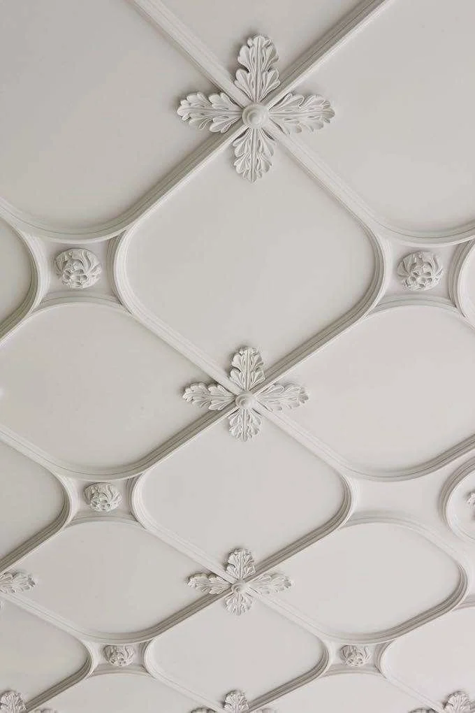 “Elegant ceiling detail with classic beige molding and ornamental trim in traditional architectural interior design”3