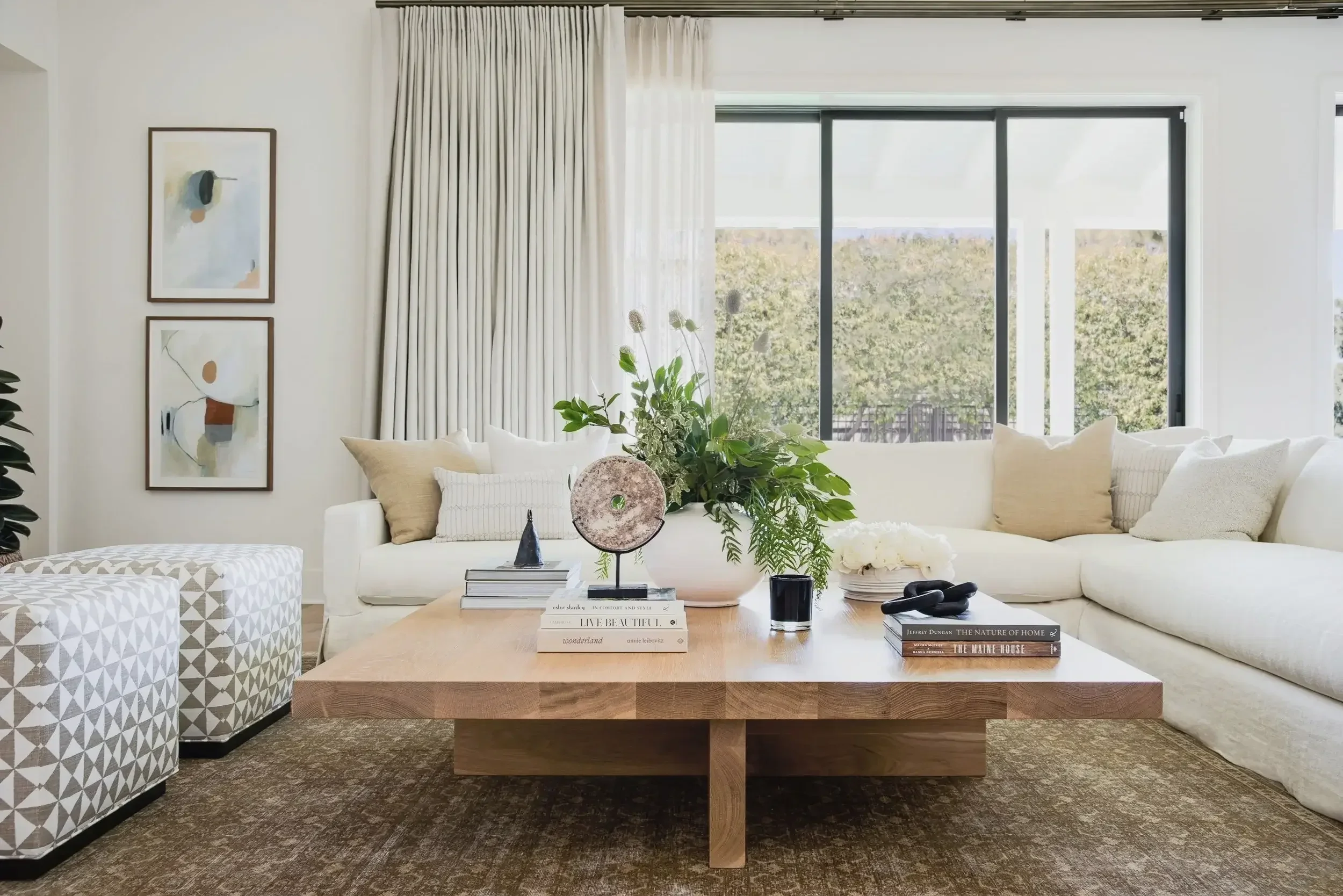 Bright+neutral+luxury+living+room+in+Newport+Beach+CA+with+large+sectional+sofa,+abstract+artwork,+and+custom+wood+coffee+table+by+Interior+Designs+By+Tiffany.webp