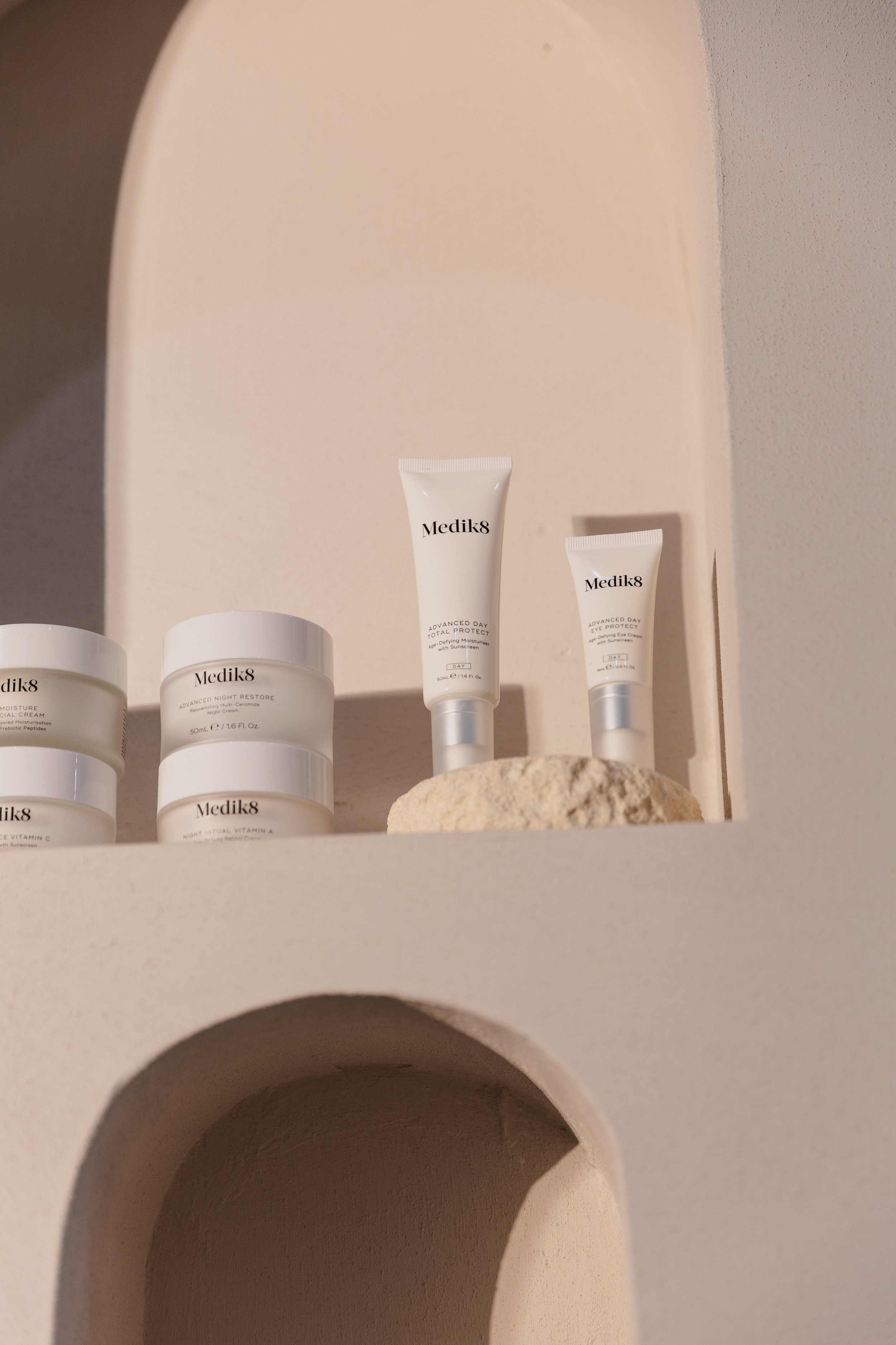 Skincare products on a shelf, including Medik8 day and night creams and eye protection.