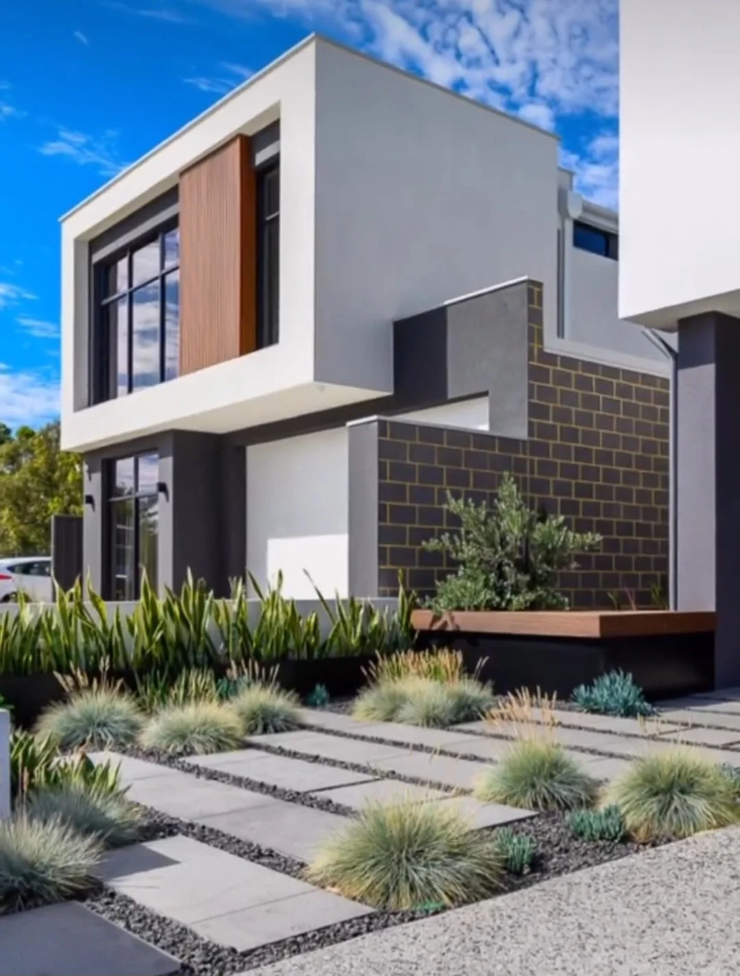 Contemporary front garden with rectangular steppers and tree deck