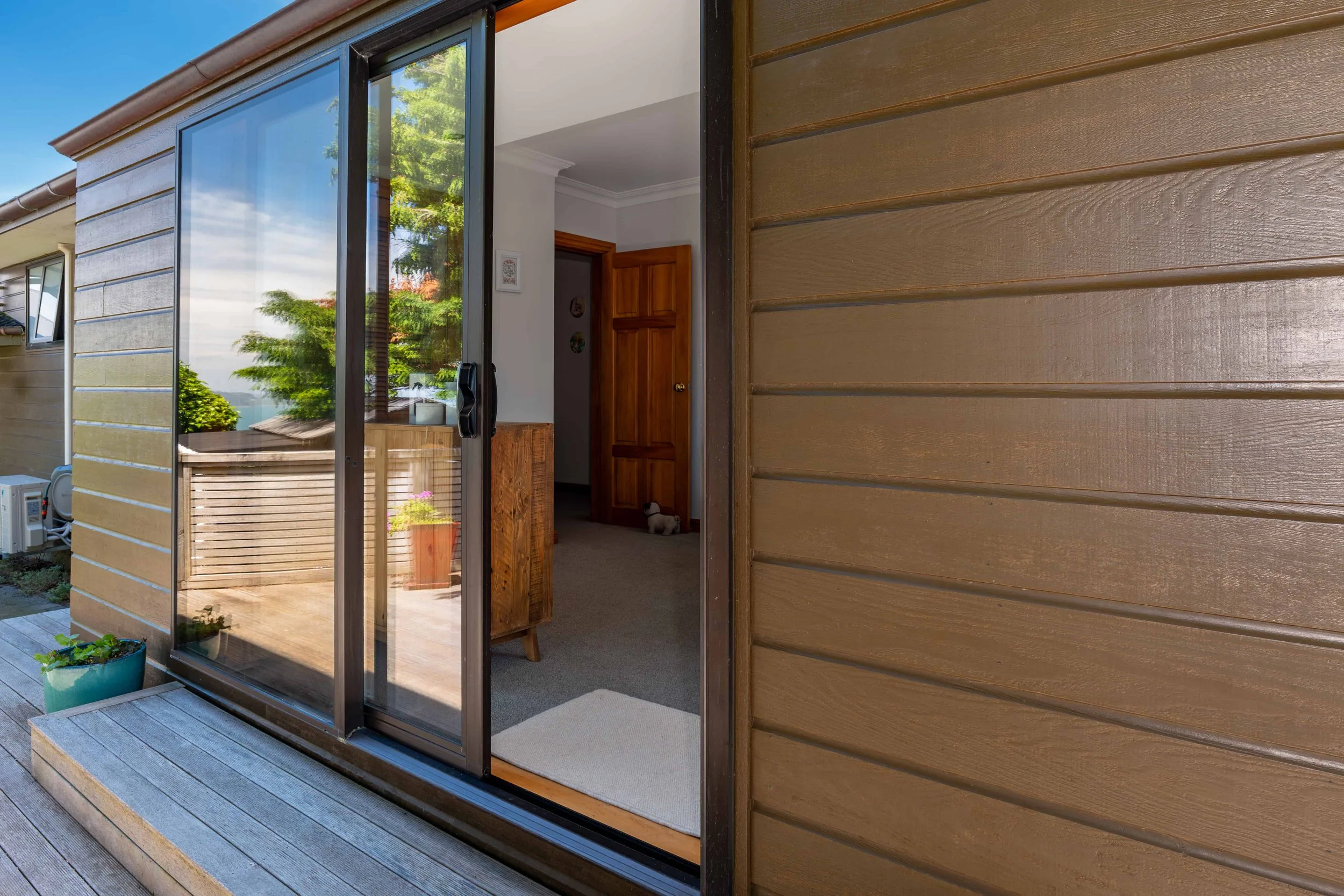 External view of a bronze anodised aluminium sliding door that Eversure double glazed. reFIT Ali service