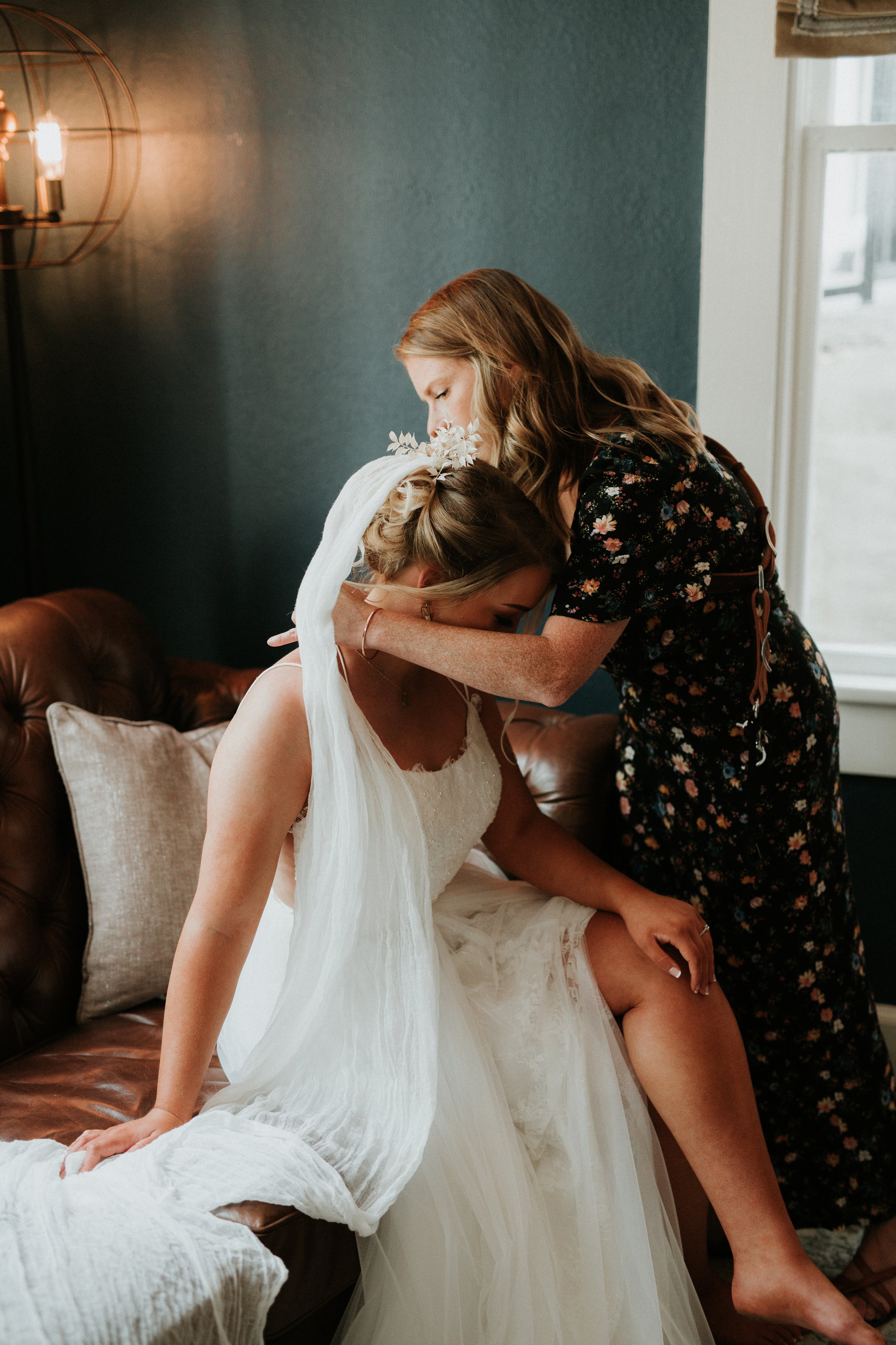 Wedding photographer putting bride's necklace on