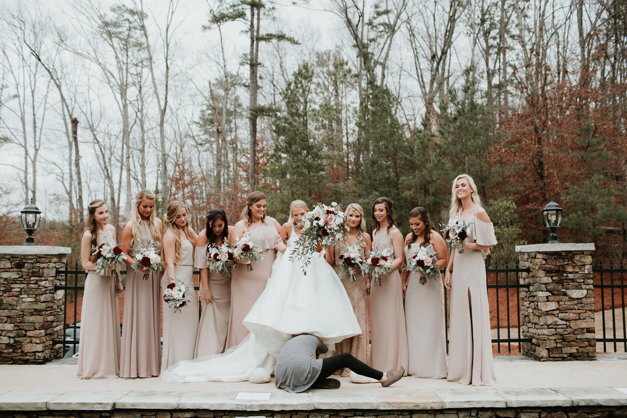 Alabama wedding photographer putting brides shoes on in Helfin alabama
