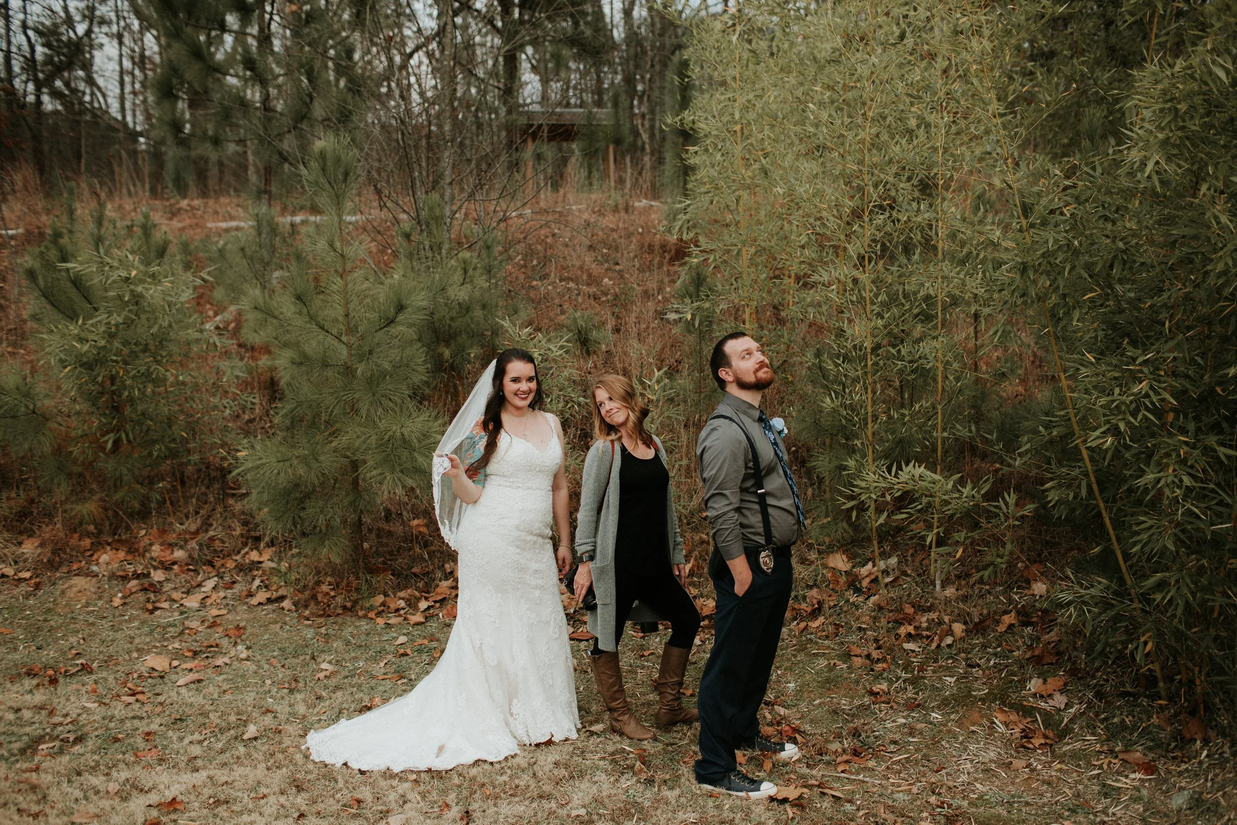 Wedding photographer helping to pose the bride and groom 