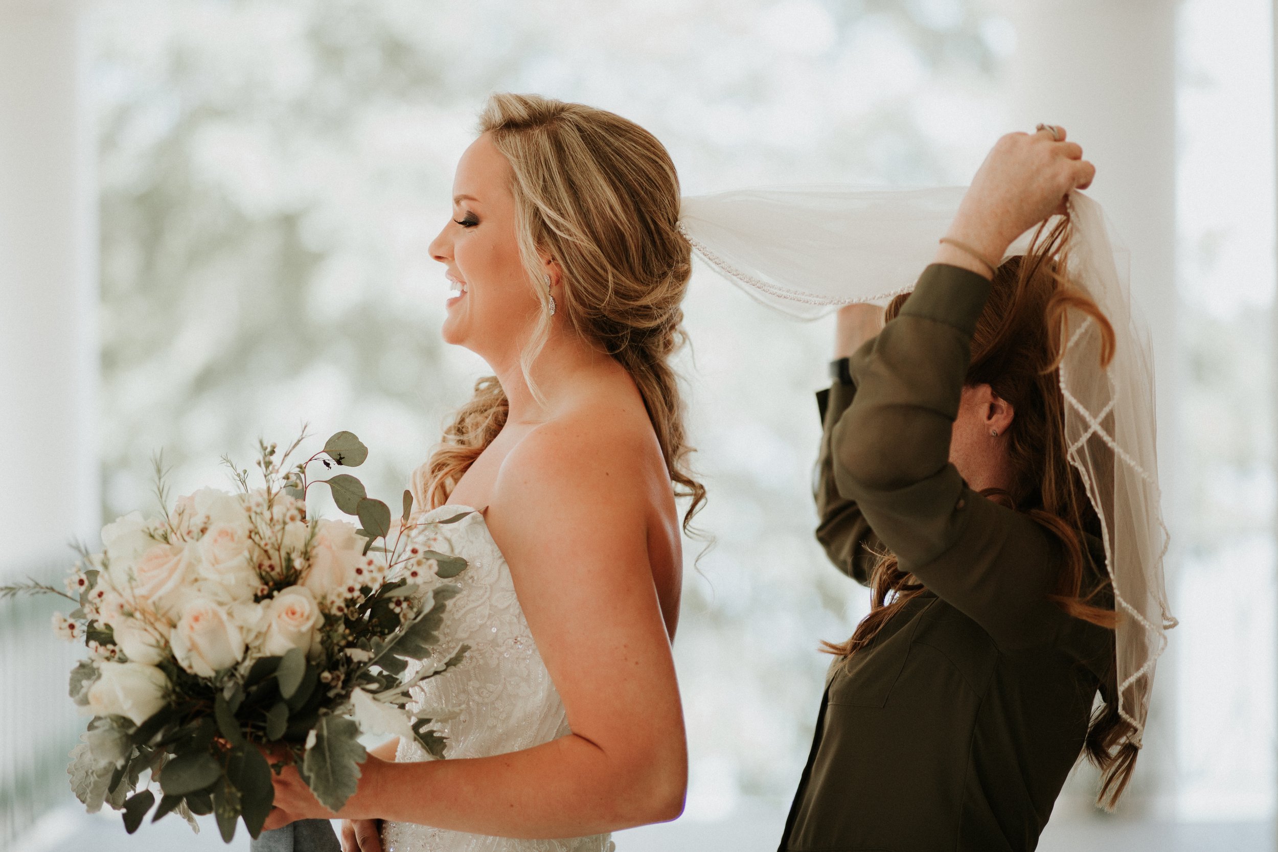 Alabama wedding photographer putting in the brides veil