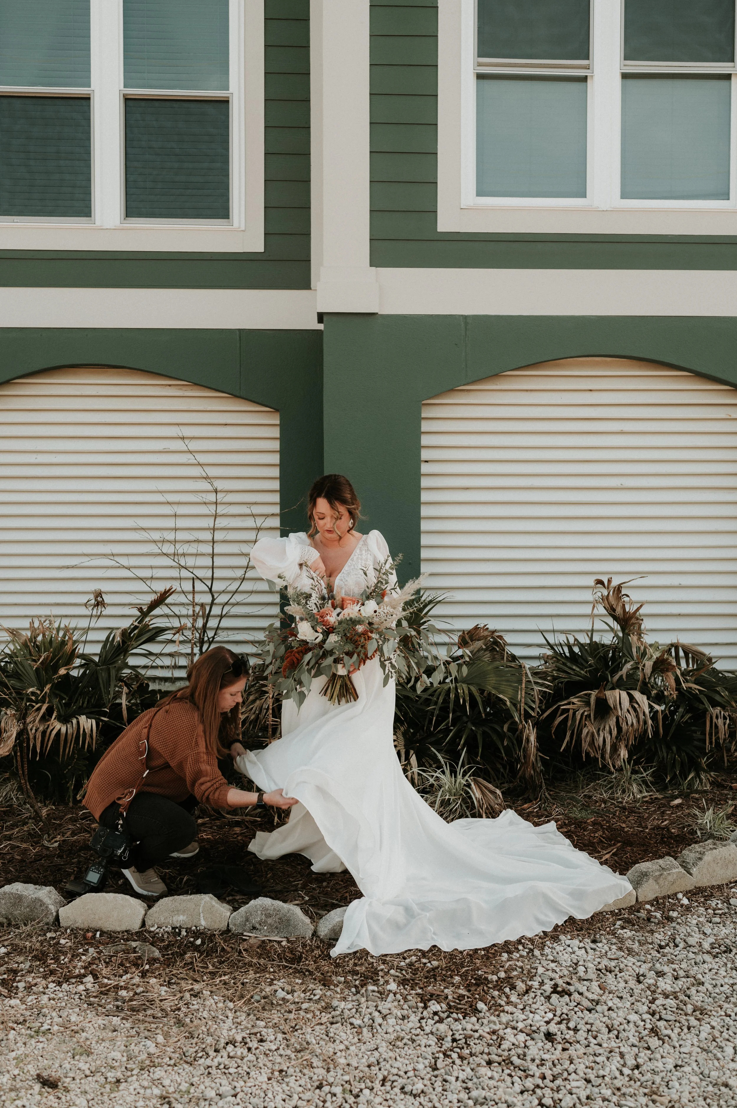 Alabama beach wedding photographer fixing the brides train