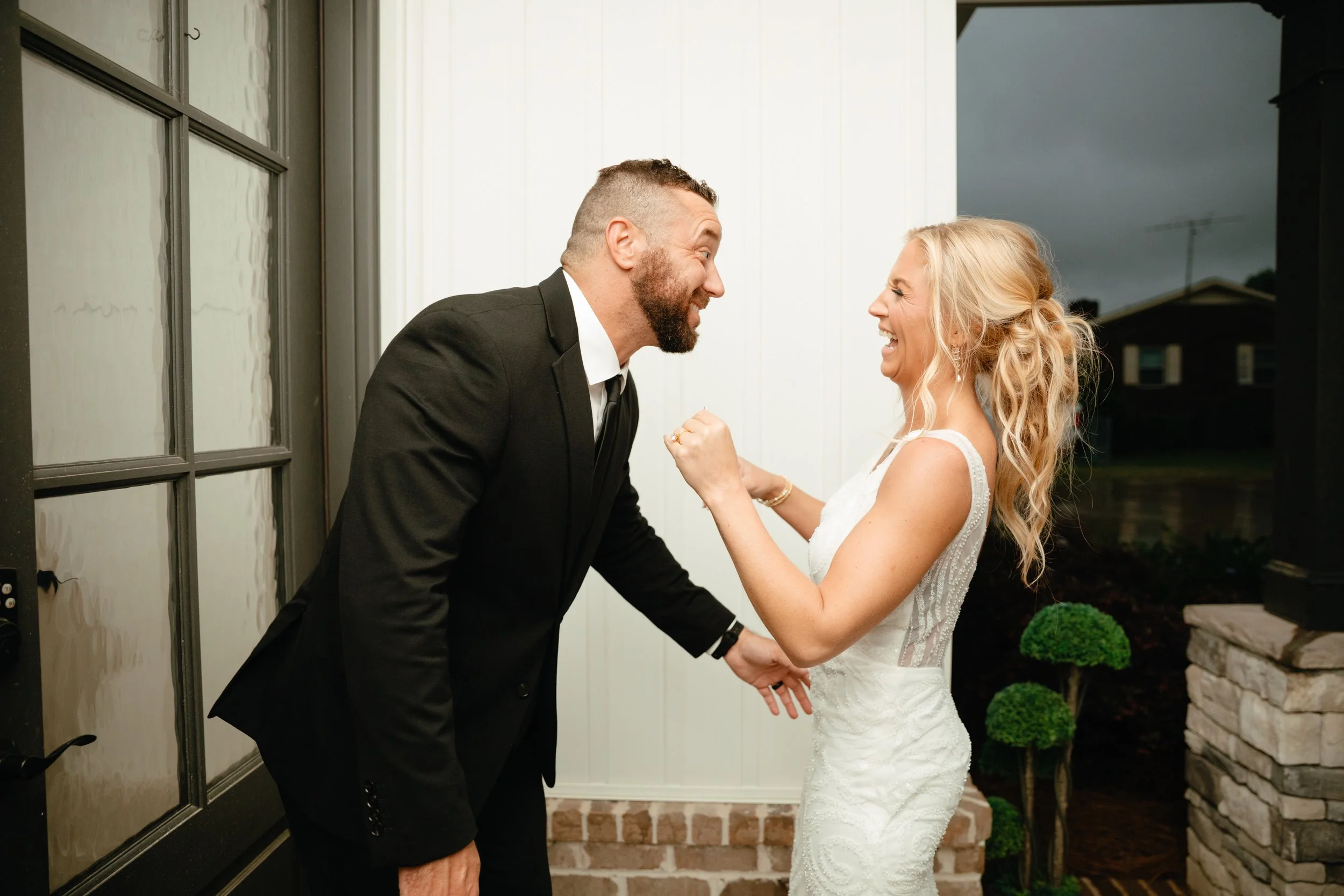 couple laughing with each other at lake house wedding in Alabama
