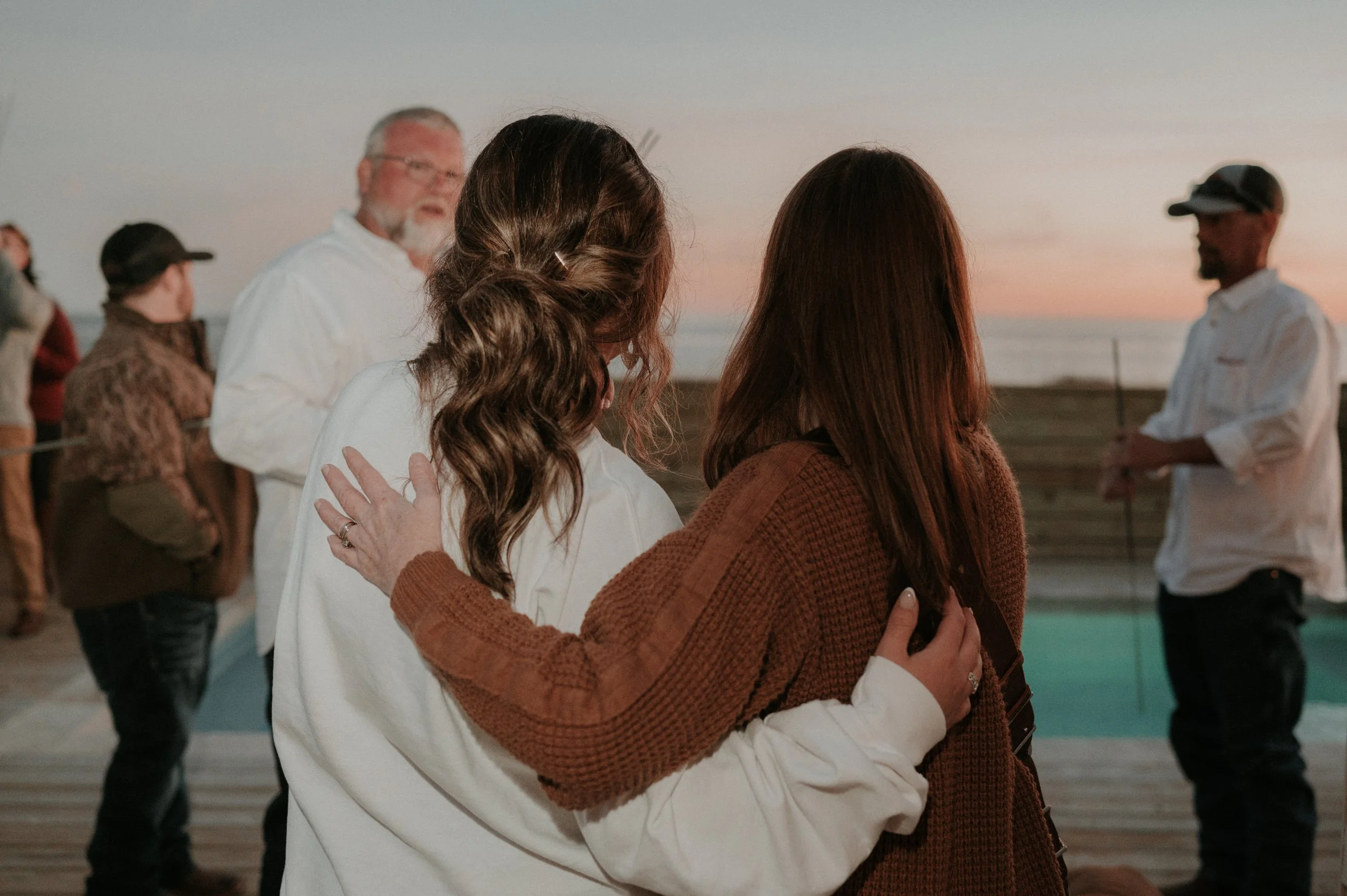 Bride and photographer hugging after a destination beach wedding