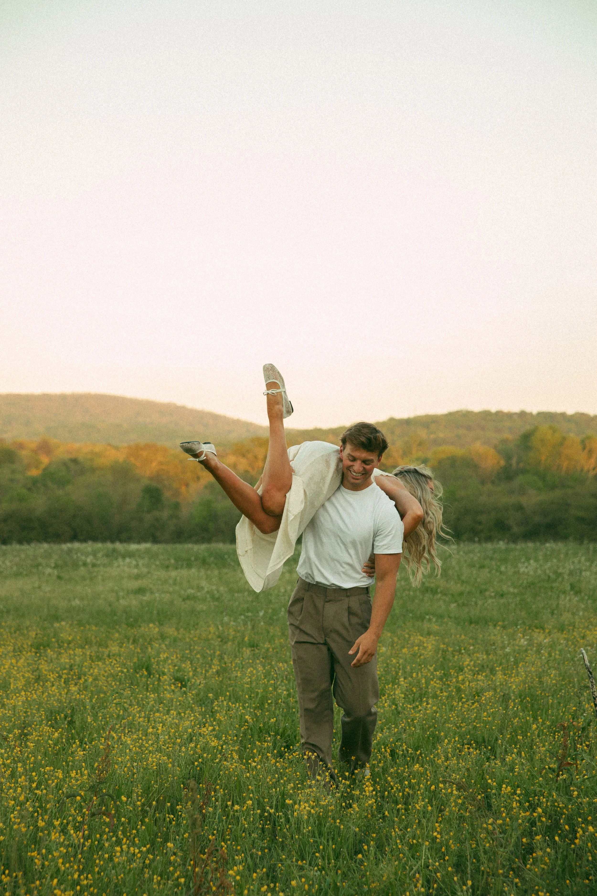 engagement couple in field with mountain view