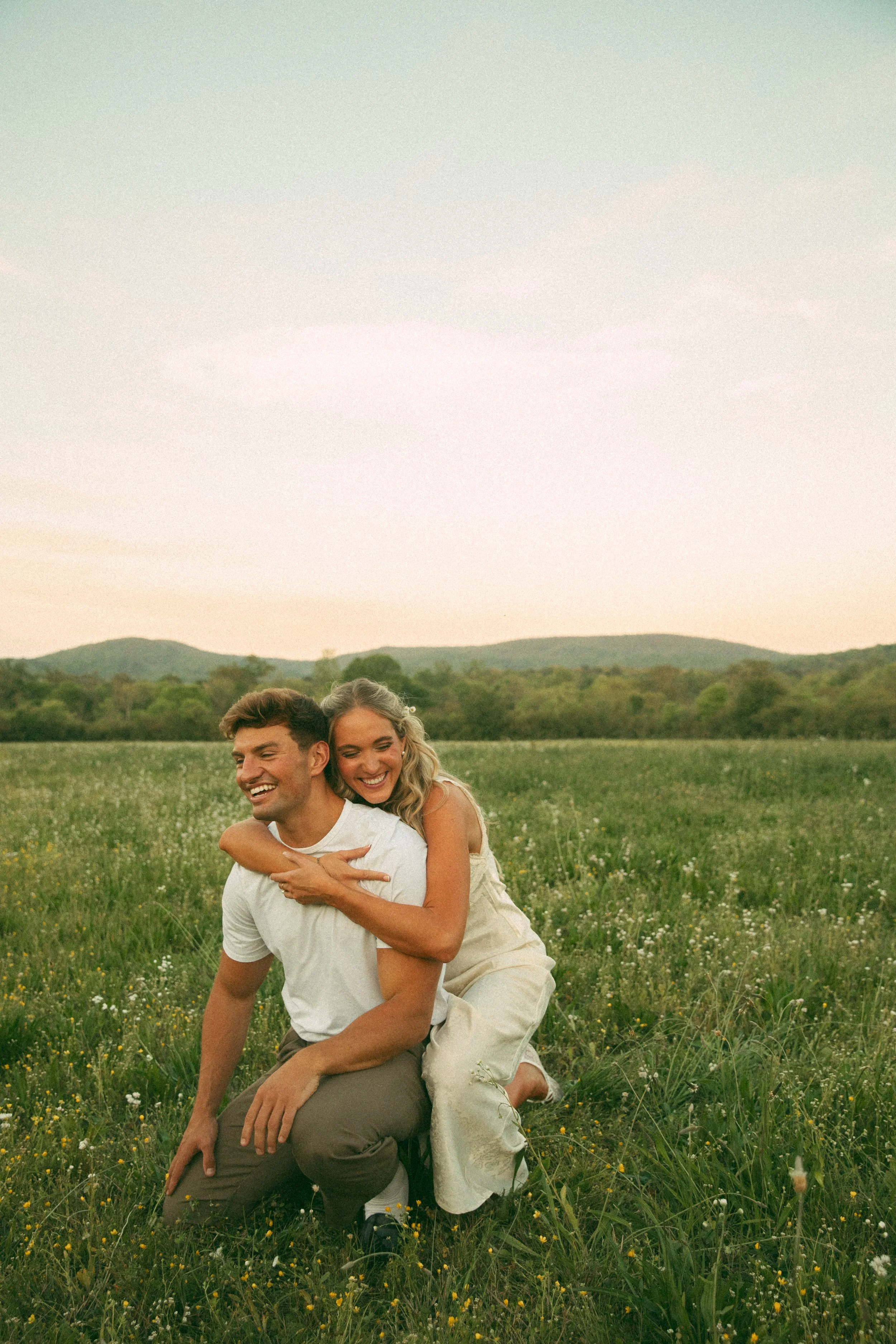 couple in a field with mountain behind