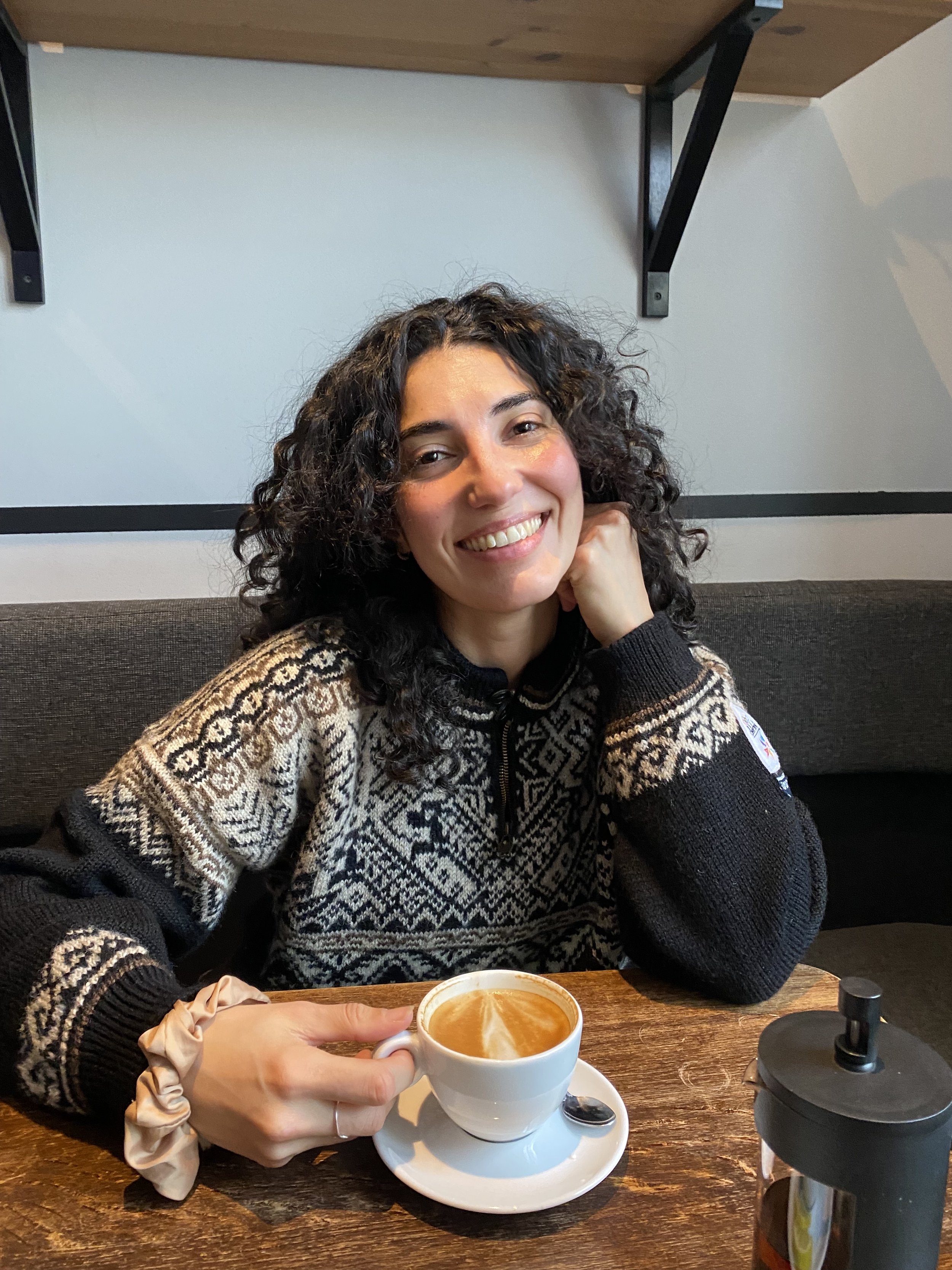 Lucyna, Ella Travel Switzerland advisor, smiling at a cafe table.