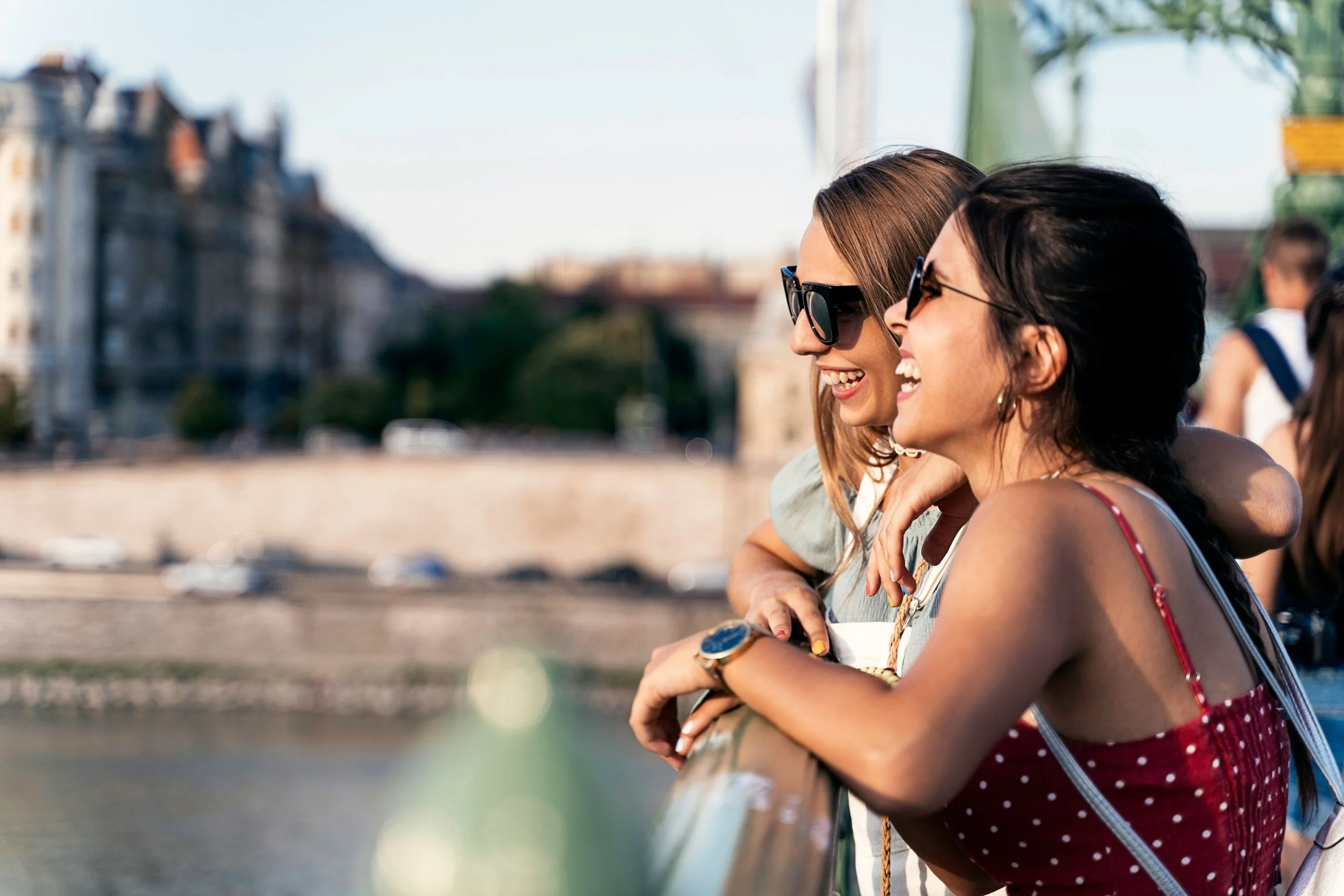 Two women in sunglasses on a historic city terrace during a custom travel trip.