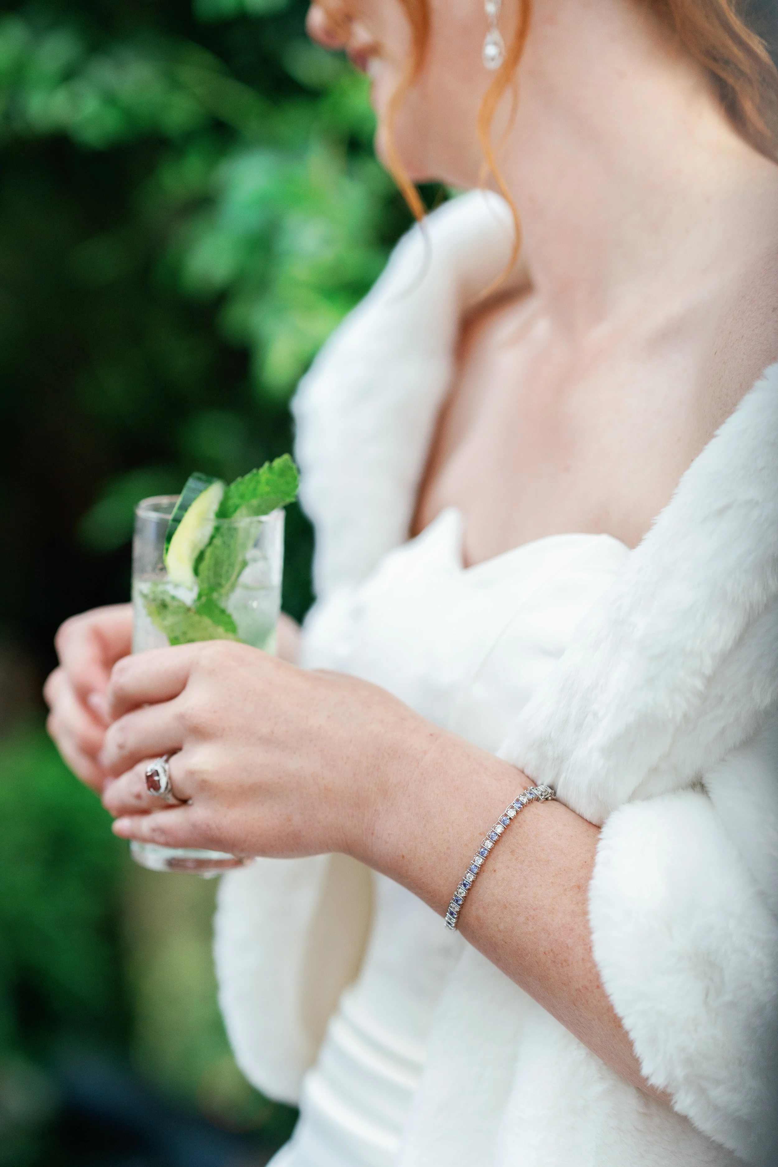 luxury bride in a white dress holding her signature cocktail during cocktail hour