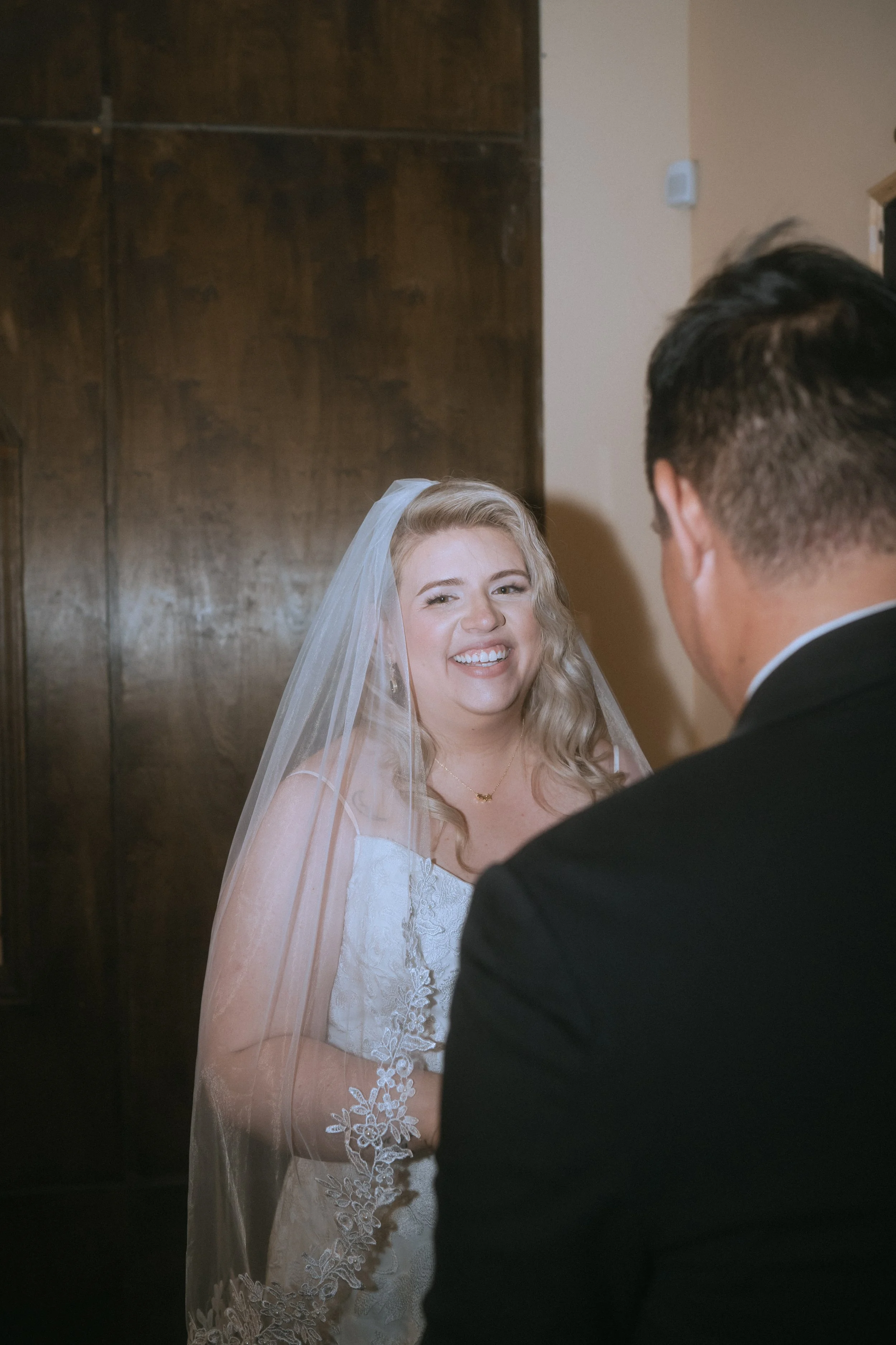 Bride smiling at groom during an intimate indoor wedding ceremony moment