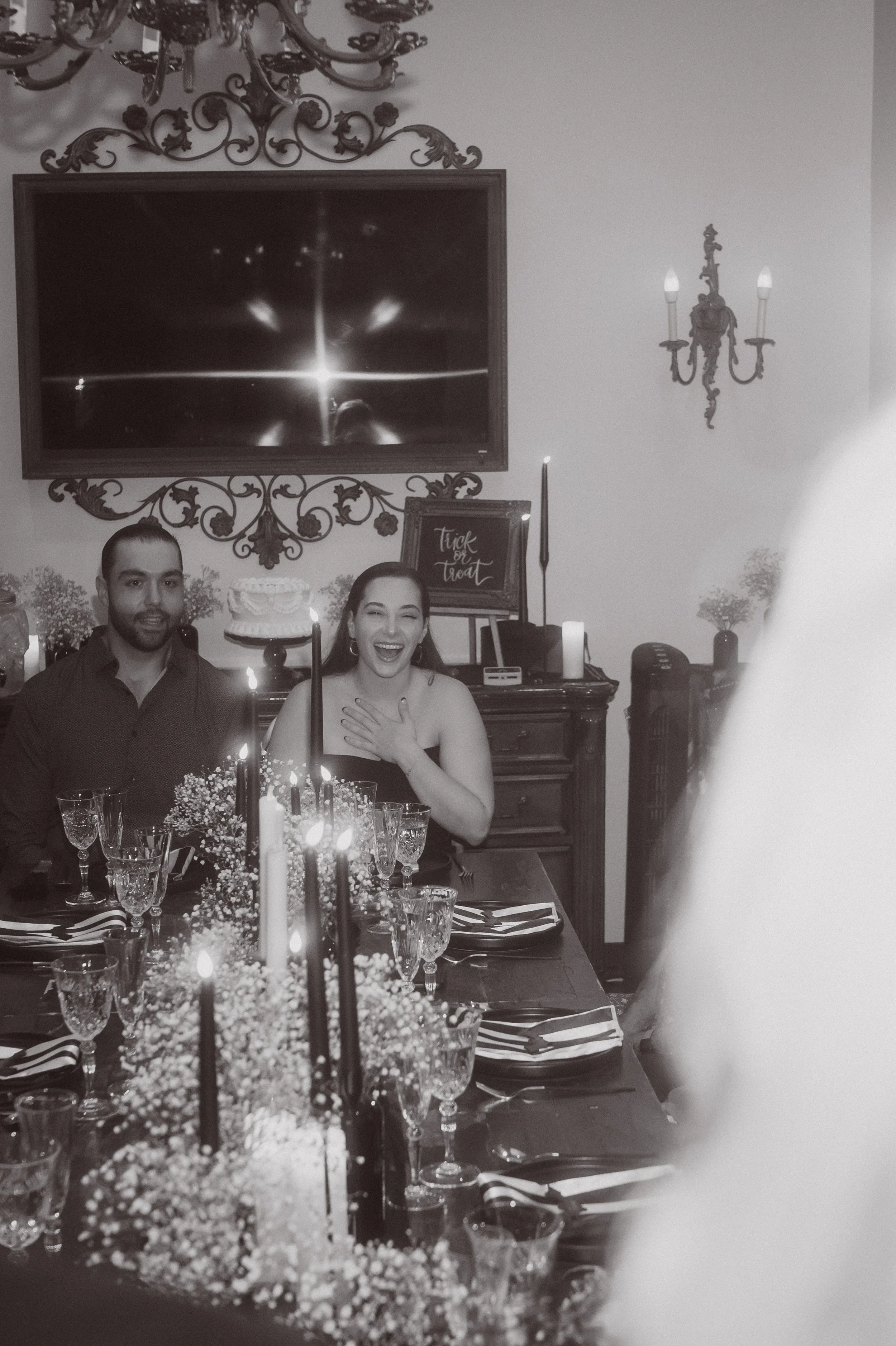 Wedding guests reacting emotionally at a candlelit reception with long tables and floral centerpieces
