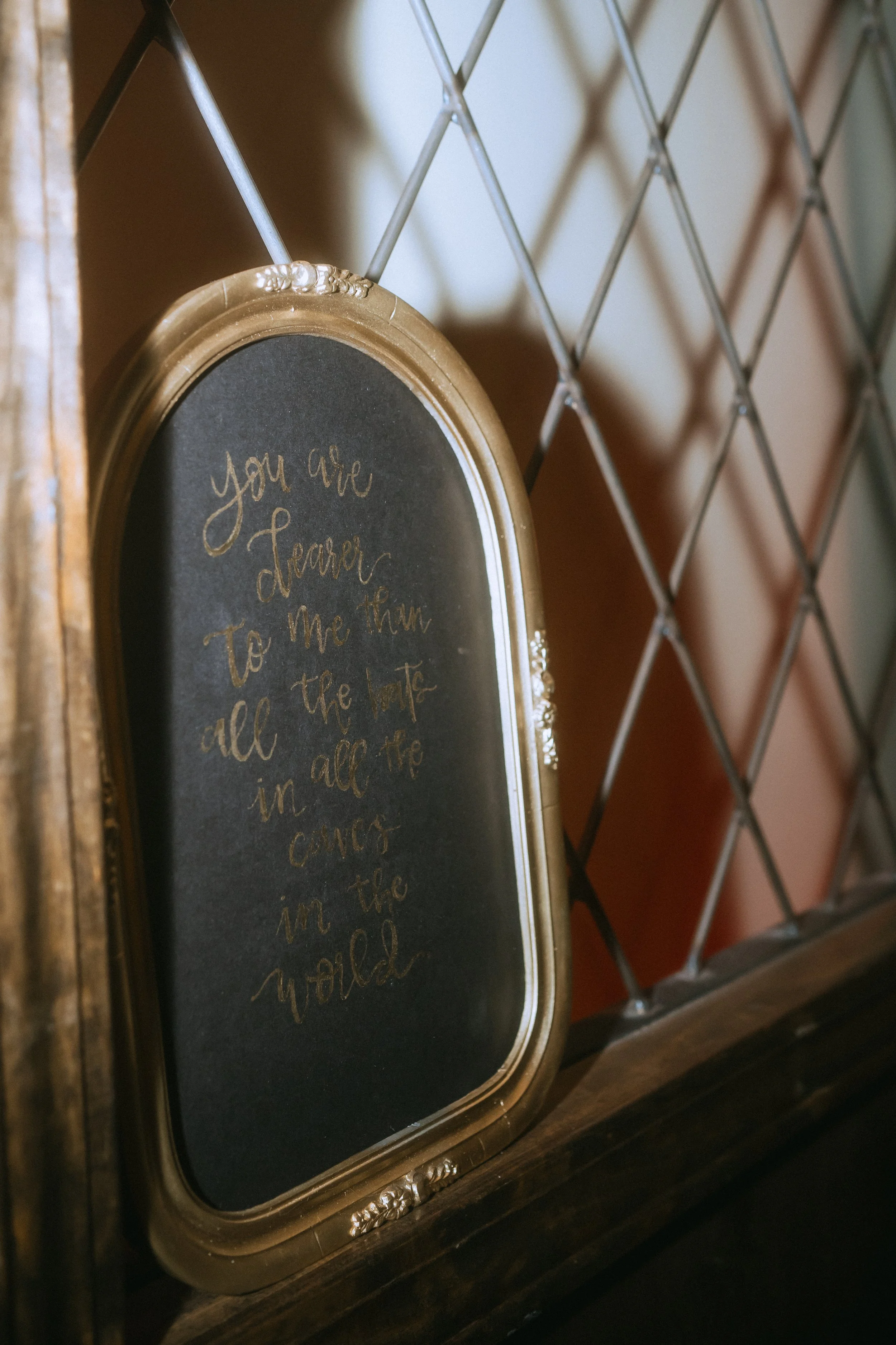 Framed wedding decor sign with romantic quote displayed on a wall inside the venue