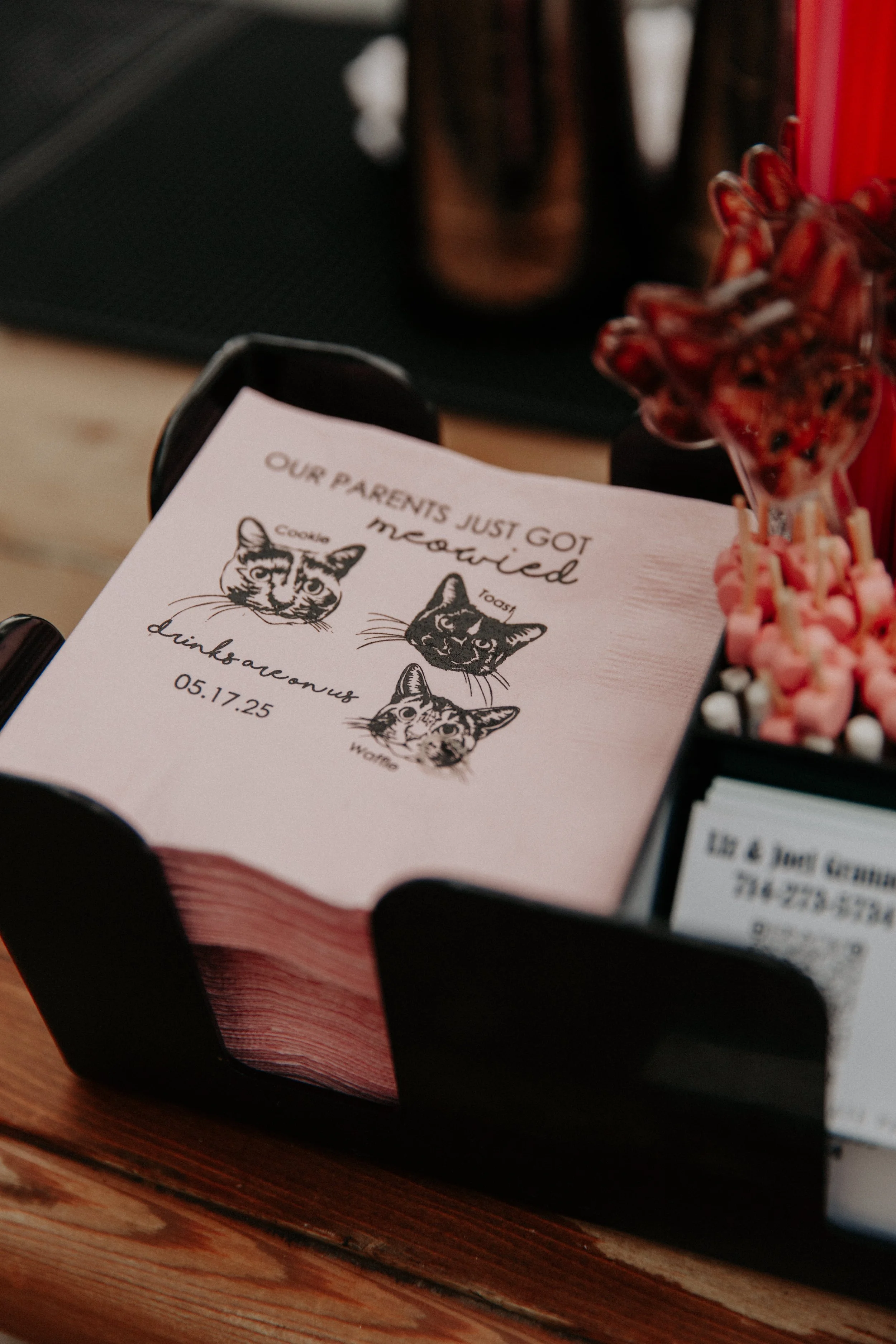 Personalized cat-themed cocktail napkins displayed at wedding bar with playful alternative wedding styling