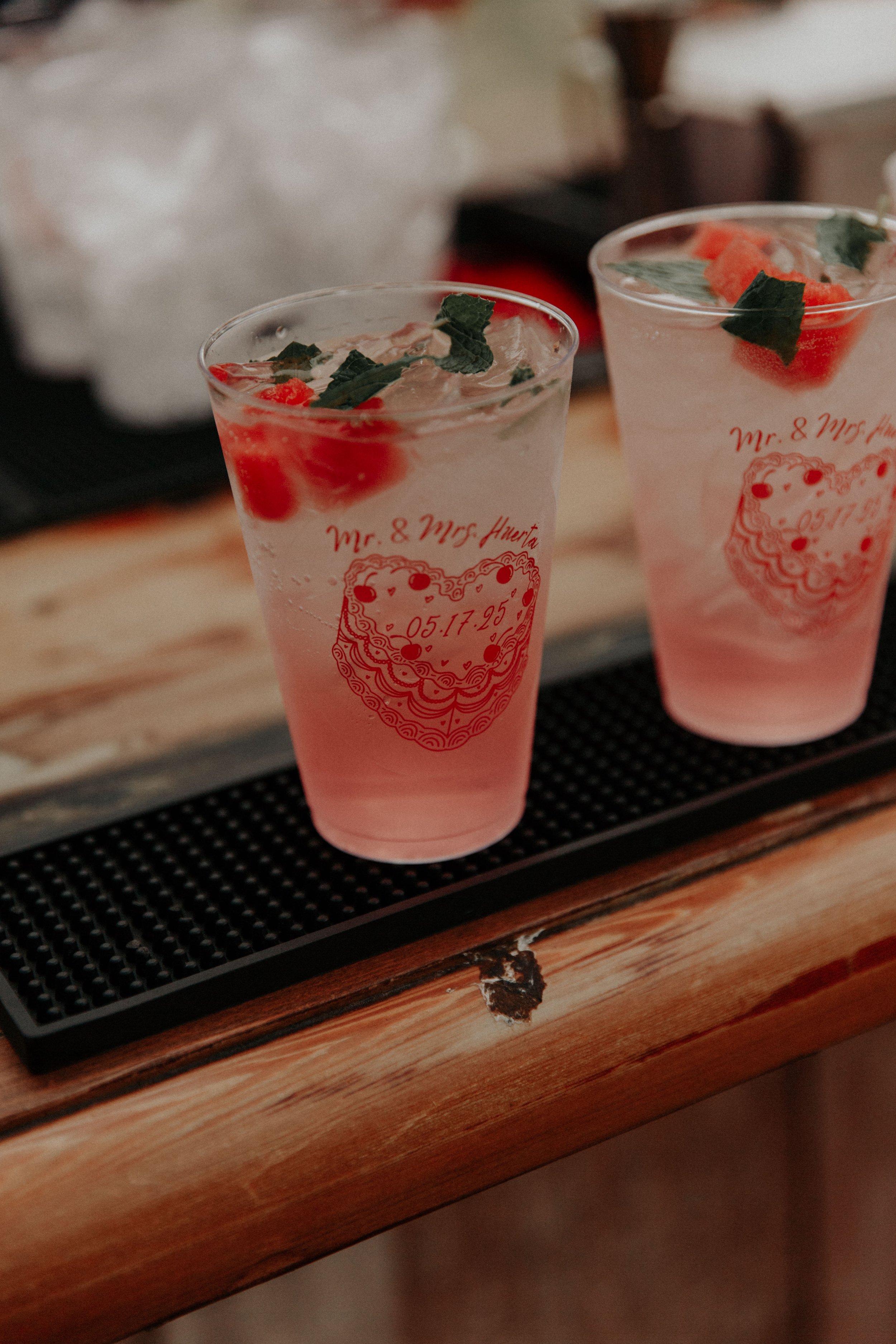 Signature wedding cocktails served in custom cups with retro heart cake illustration and personalized wedding date