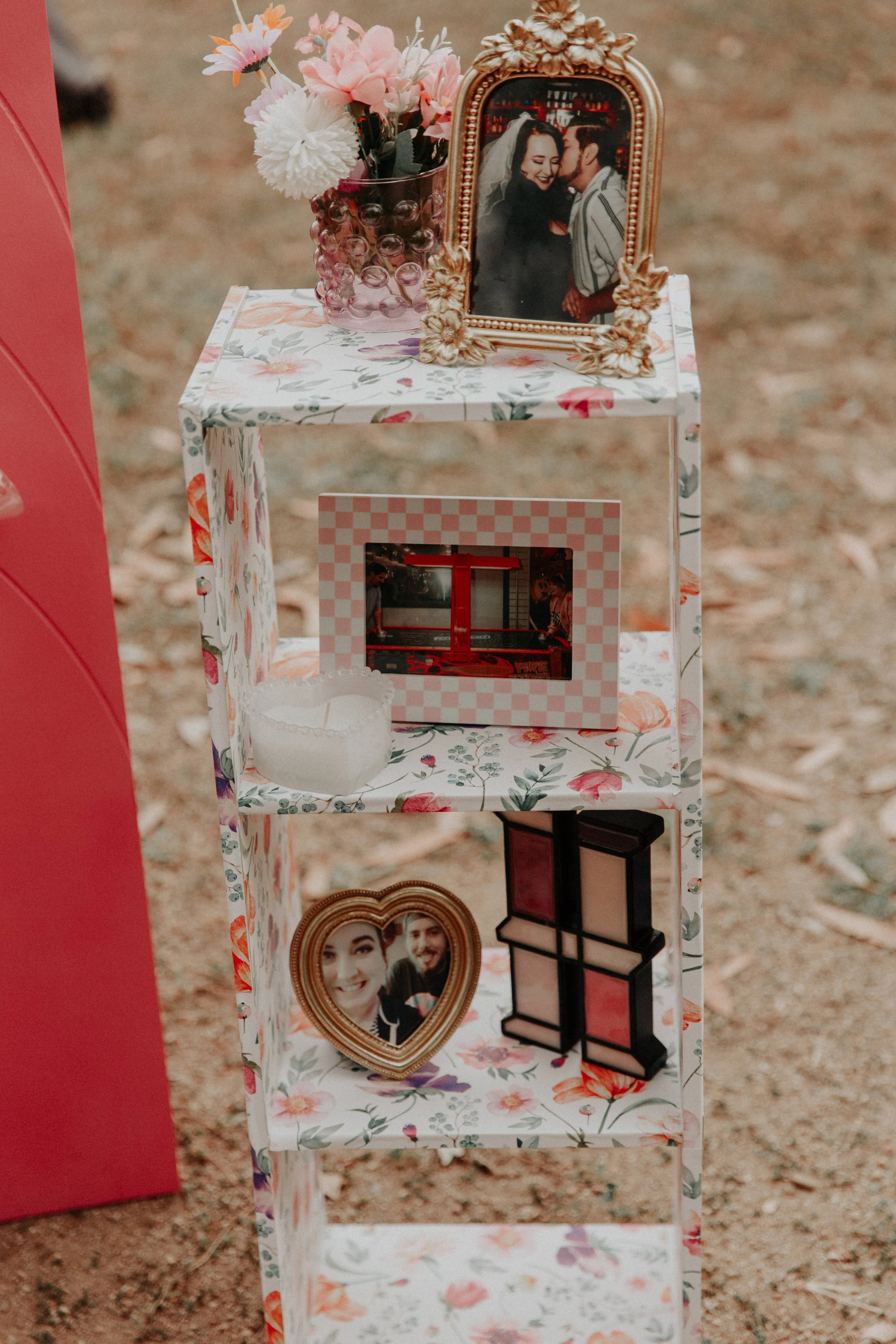 Personal photo display with floral decor and framed couple portraits at colorful wedding reception