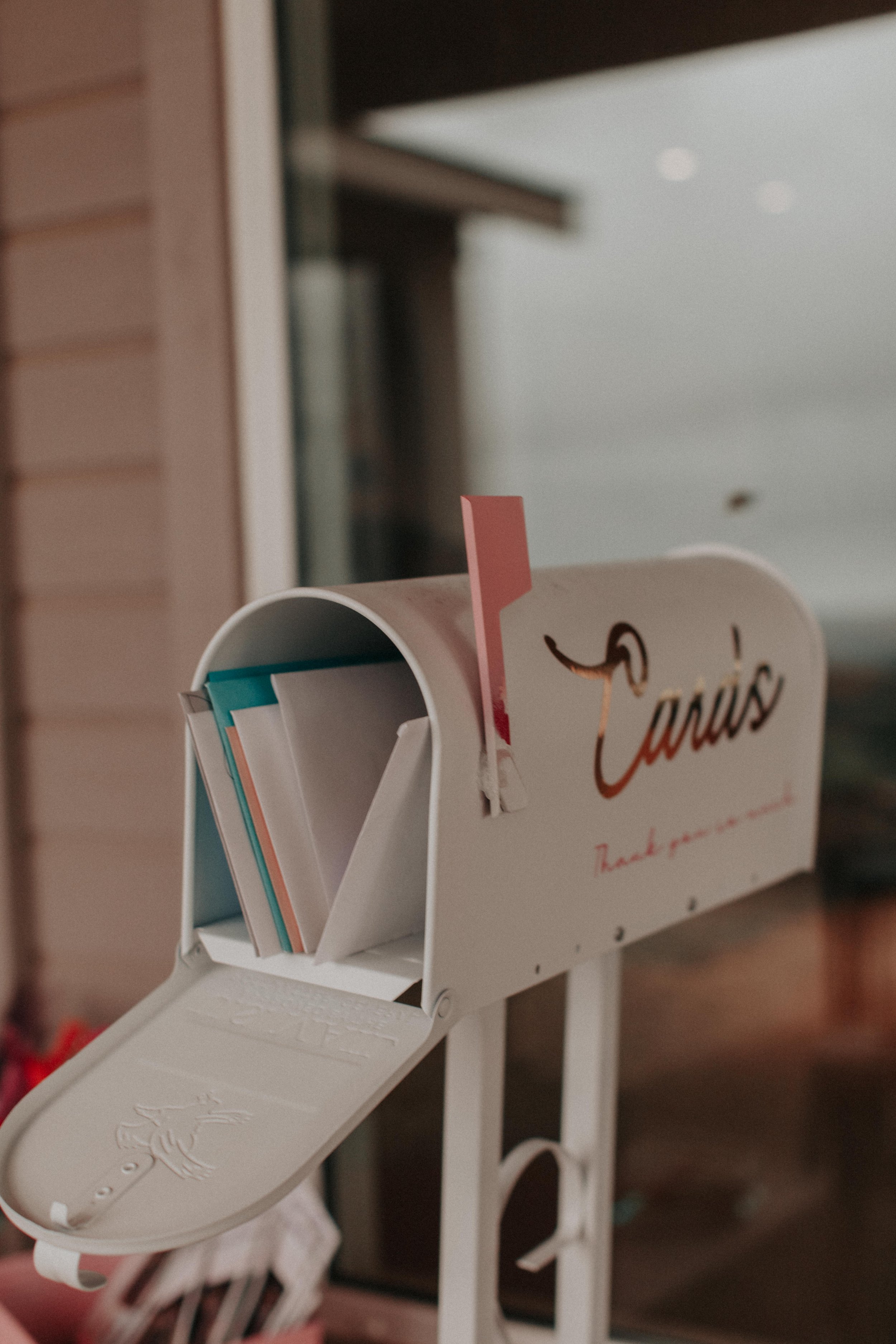 Close-up of white wedding card mailbox filled with envelopes from guests at reception