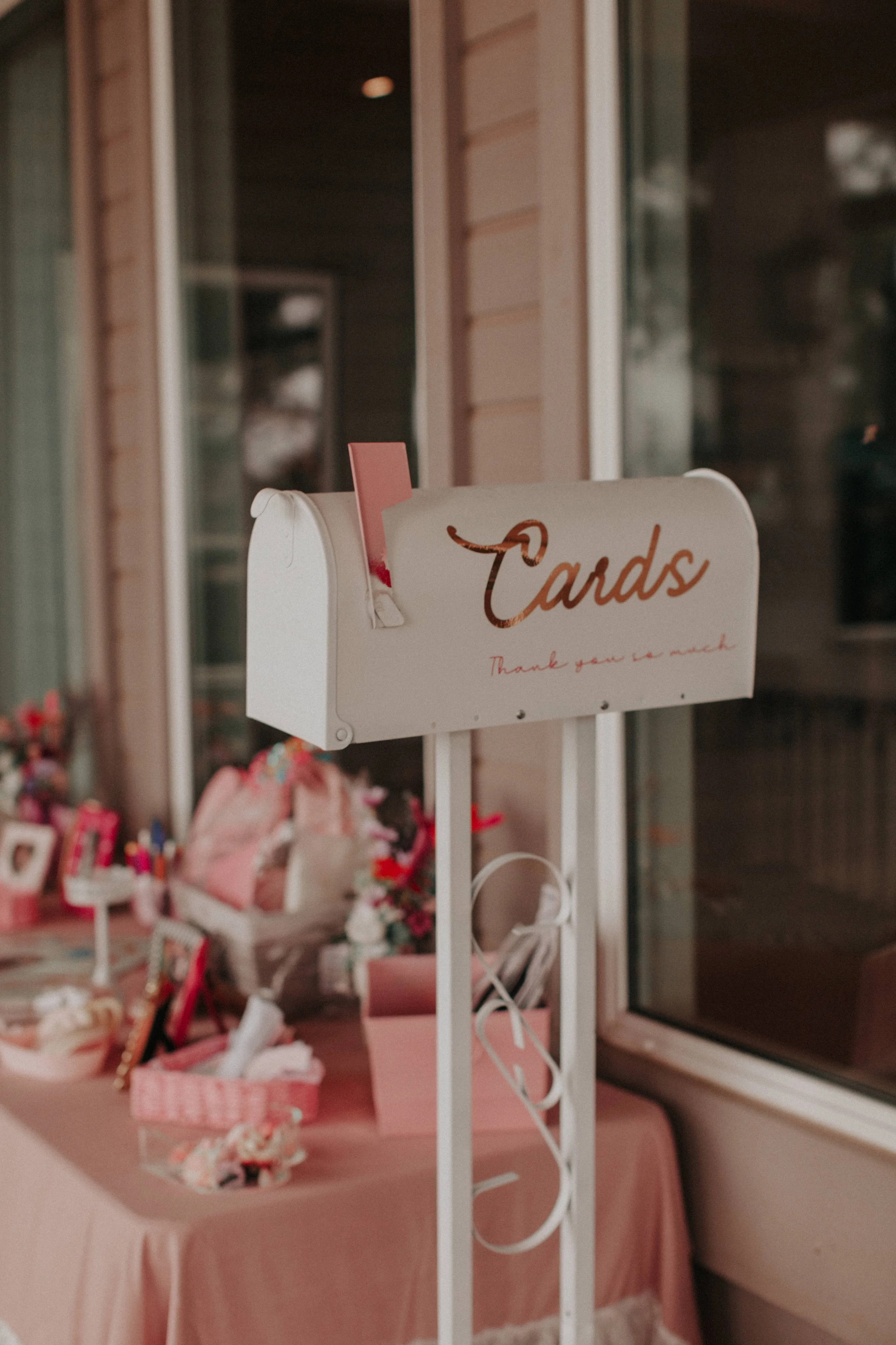 White vintage-style mailbox for wedding cards displayed beside reception guest table.