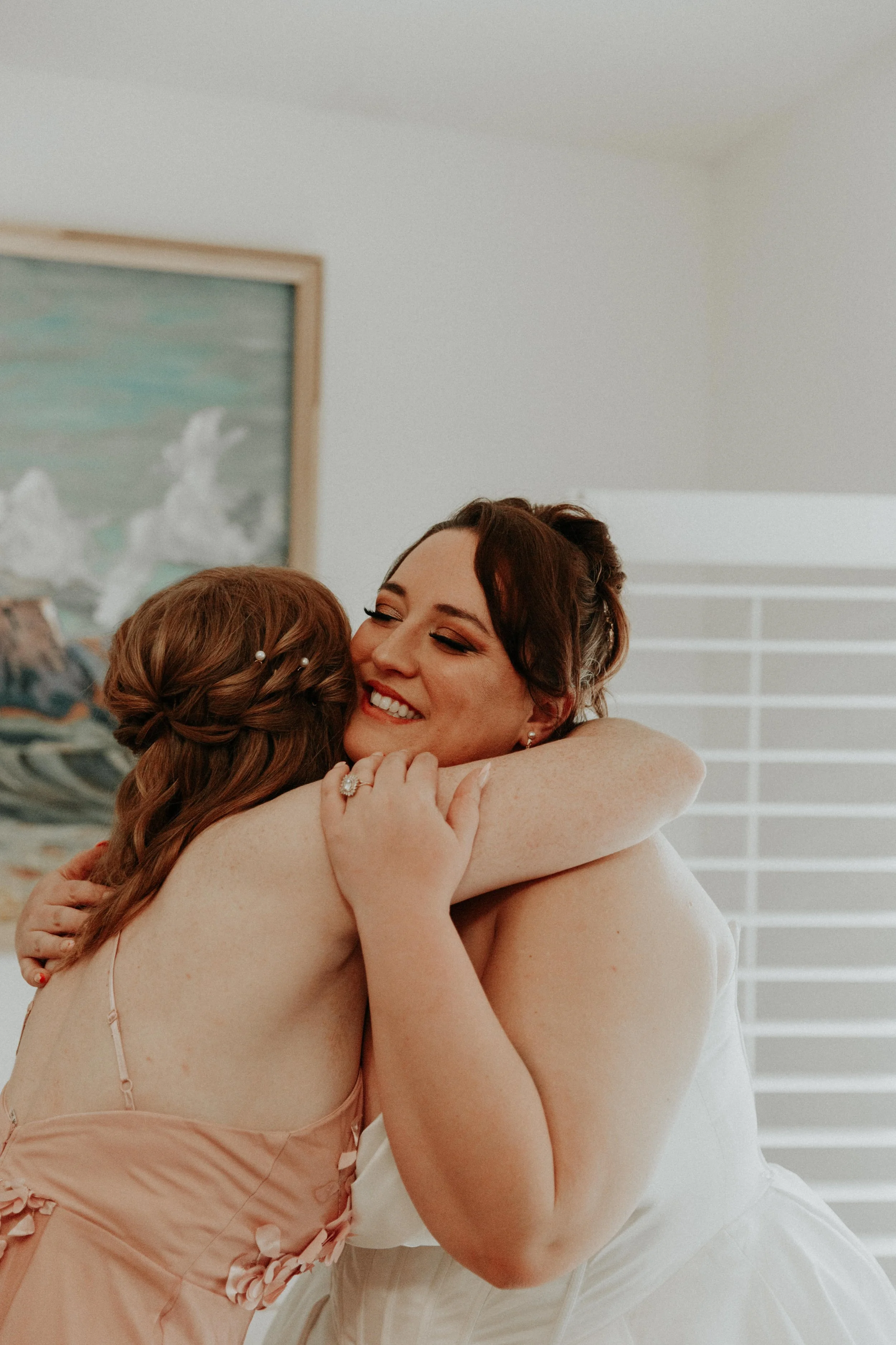 Emotional hug between bride and bridesmaid before wedding ceremony