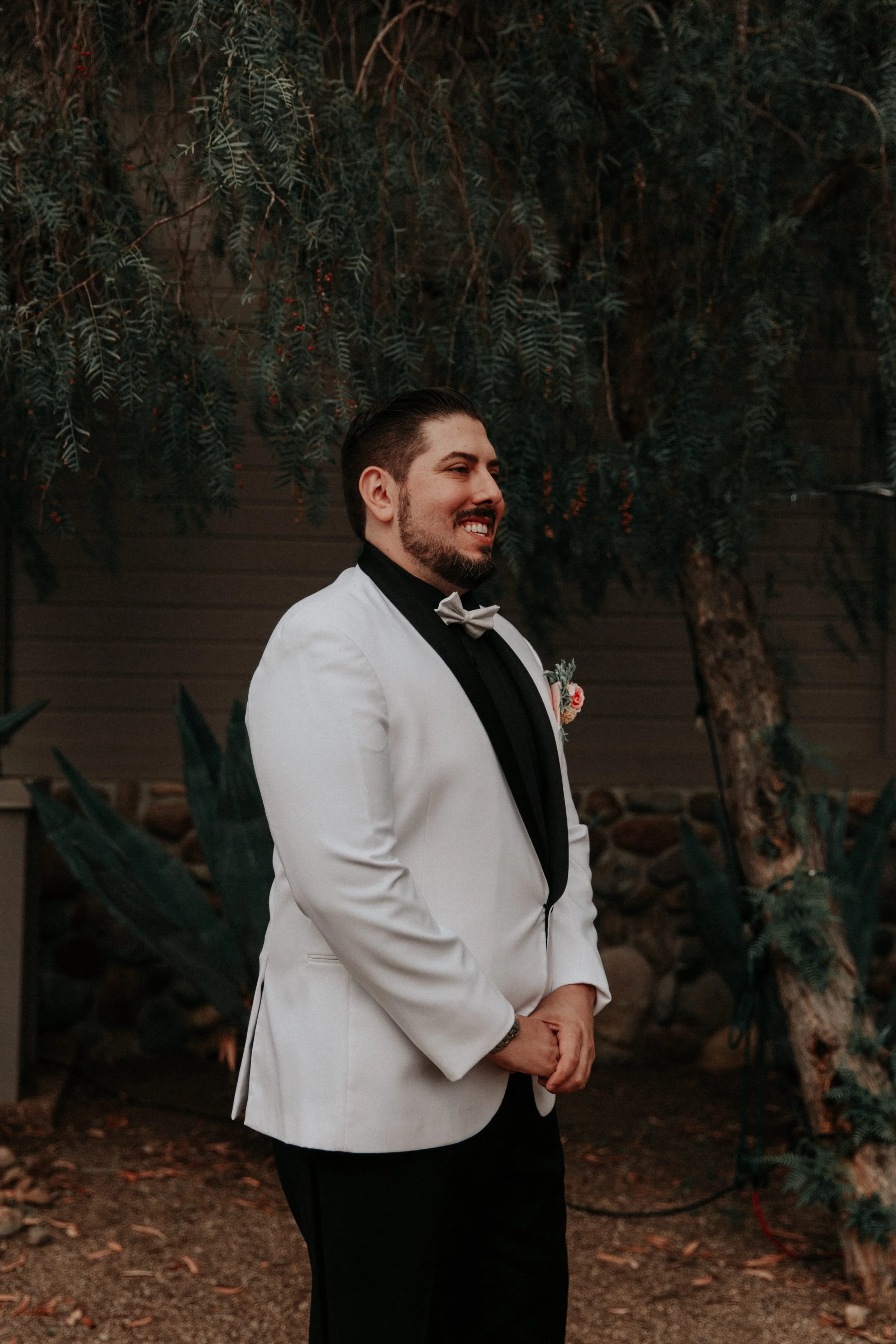 Groom smiling while waiting for first look before wedding ceremony