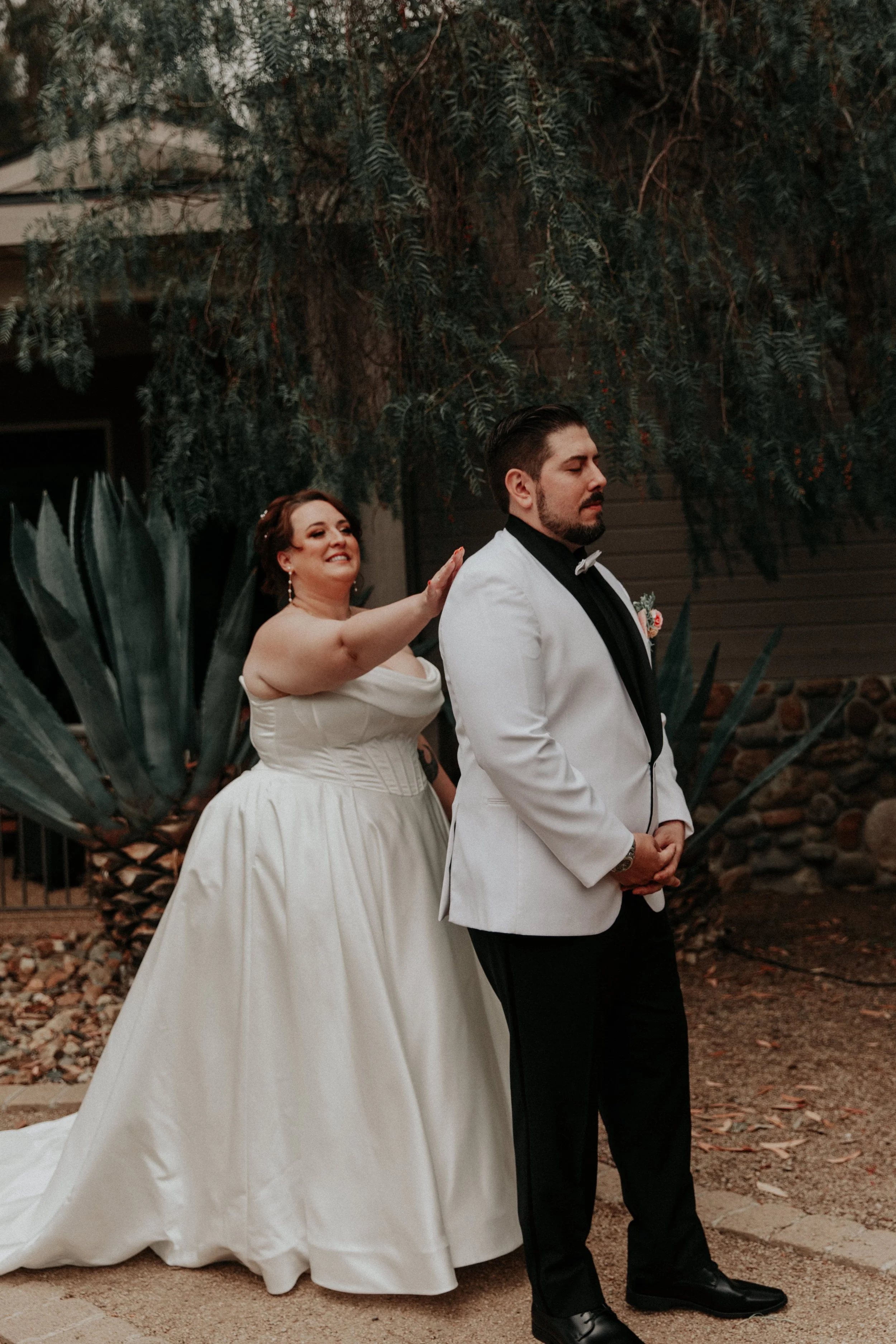 Bride tapping groom’s shoulder during emotional first look moment