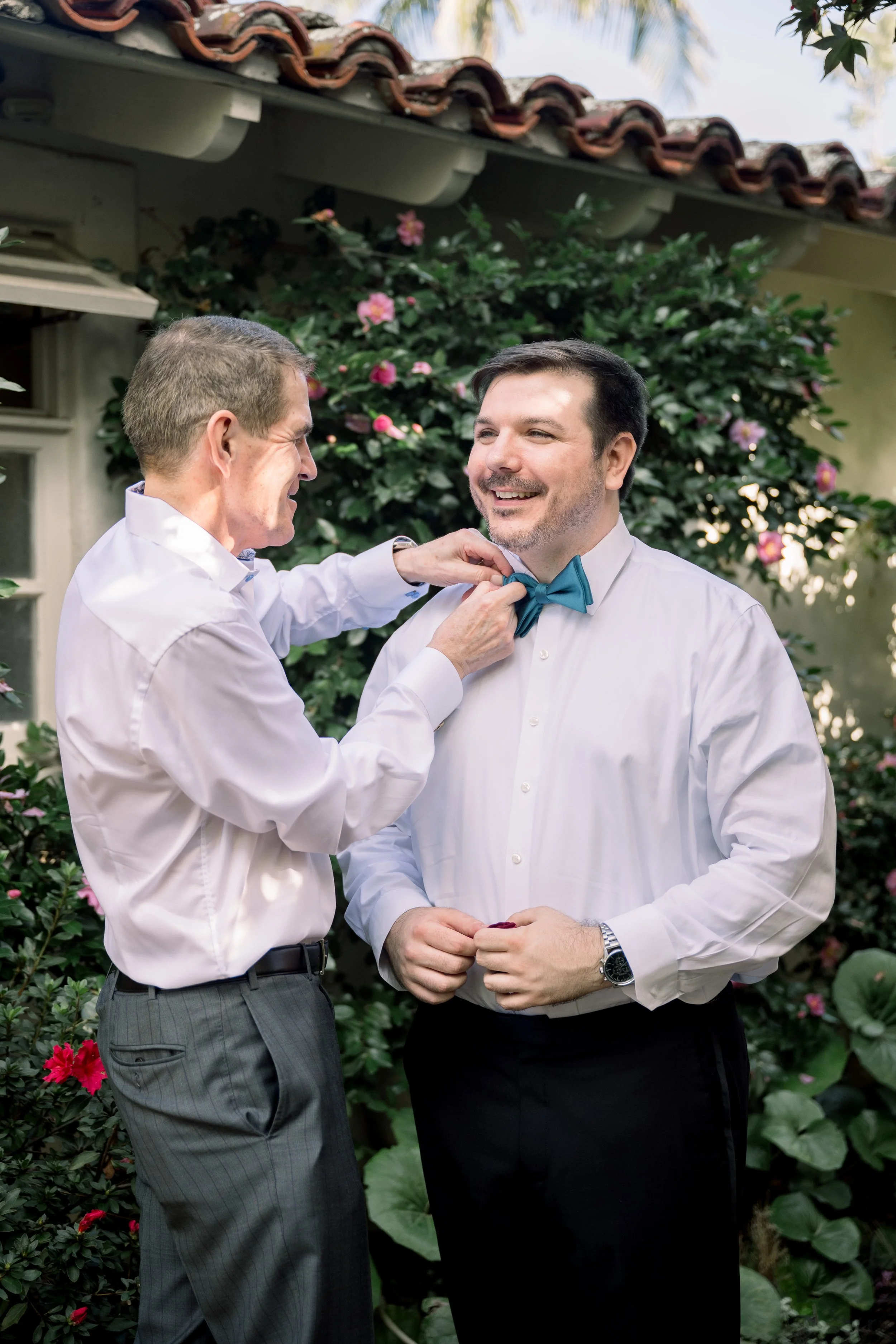 Father Helping Groom Adjust Bow Tie Before Wedding Ceremony