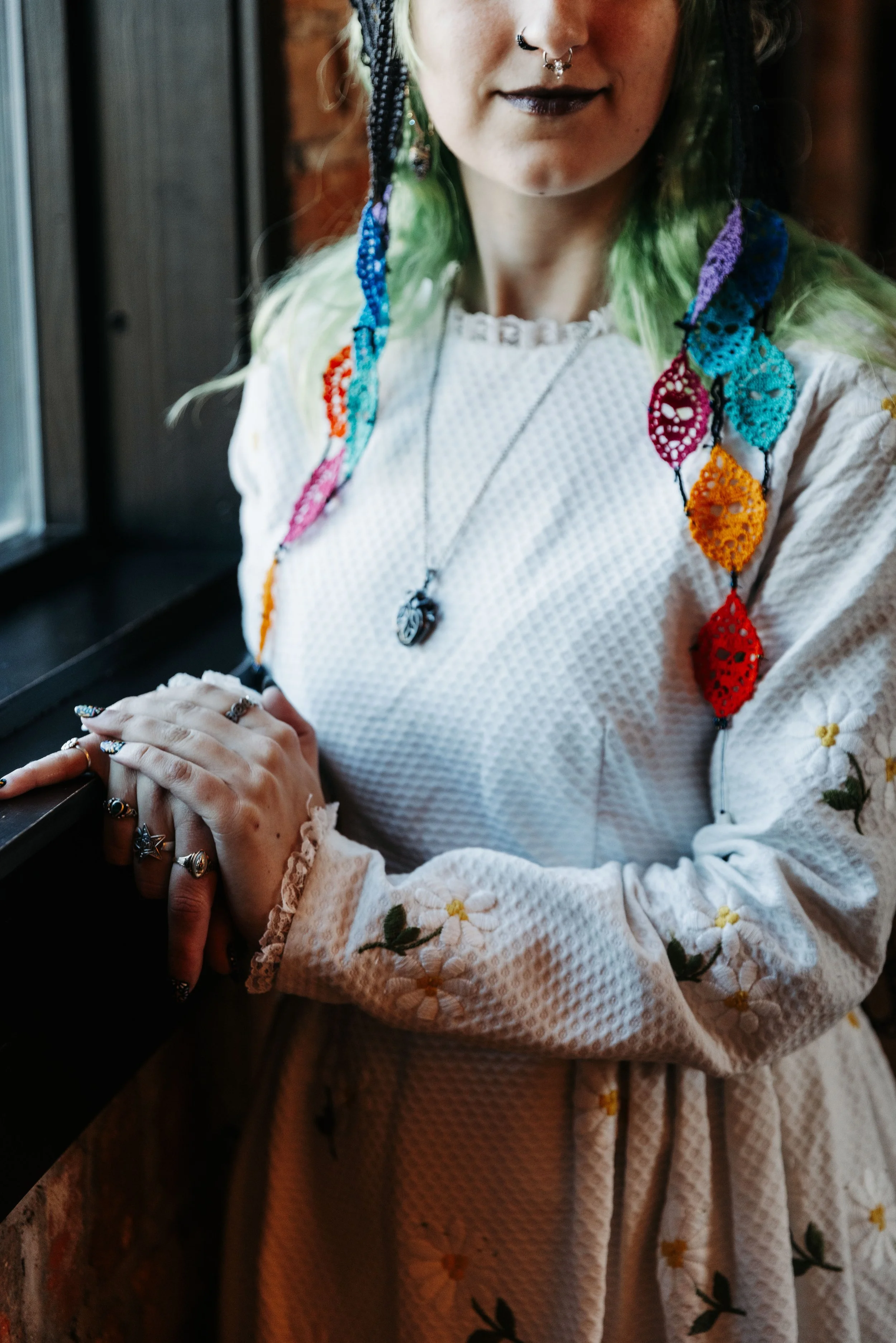 Close-up portrait featuring colorful crocheted accessories, floral embroidery, and alternative bridal styling inspired by Día de los Muertos traditions.