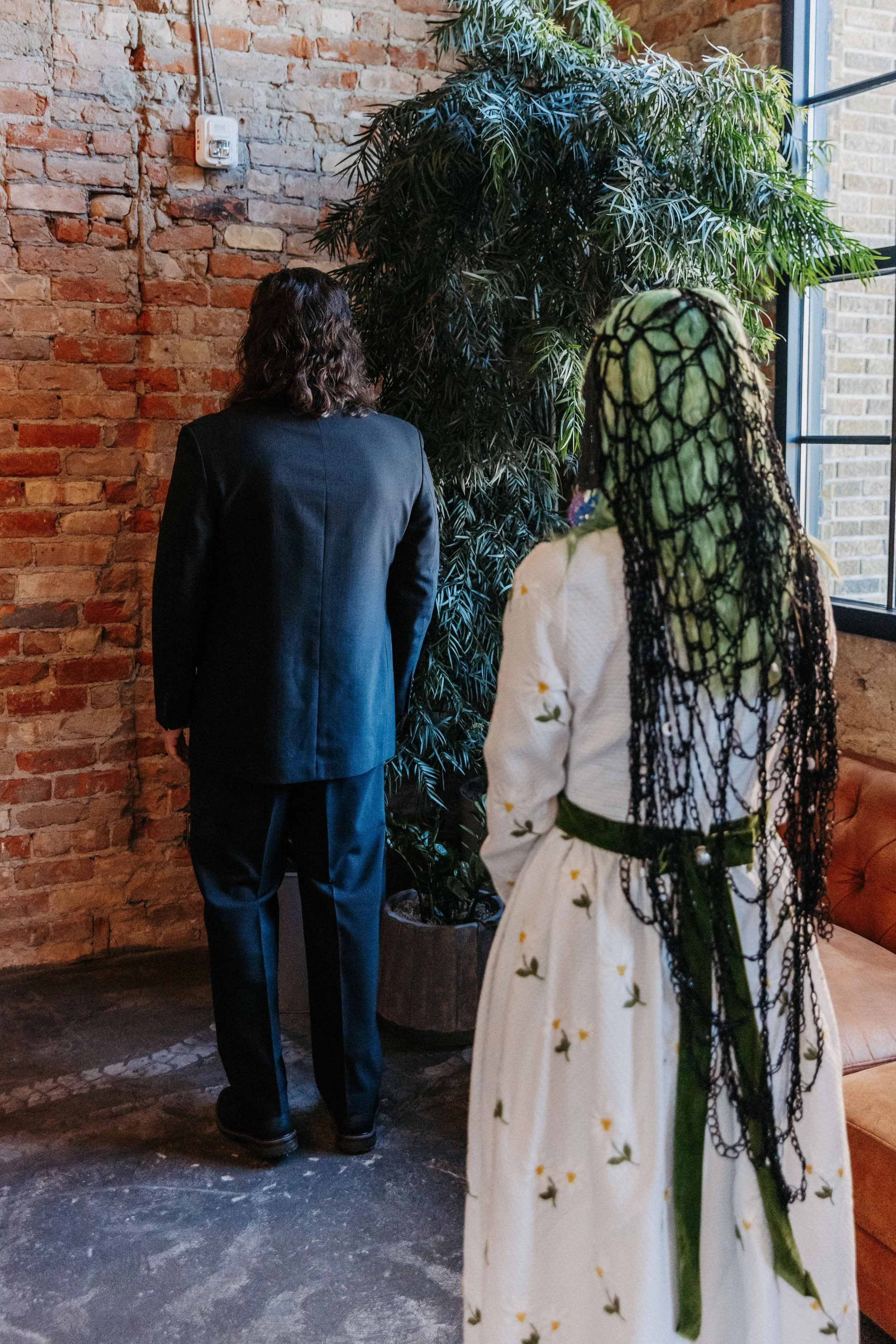 Bride approaches groom from behind during a first look inside Crescent Hall, moments before their wedding reveal.