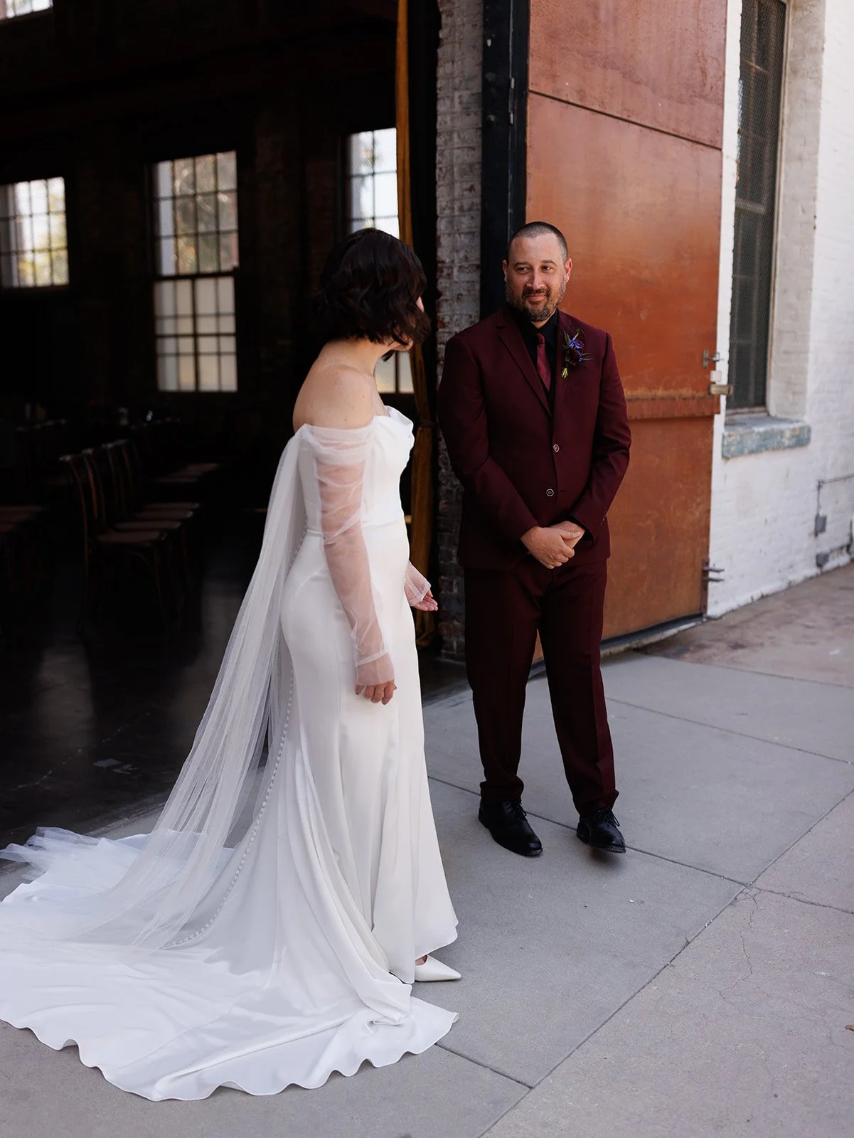 Groom smiles as he turns to see his bride during their first look, sharing a private and emotional moment before the wedding ceremony.