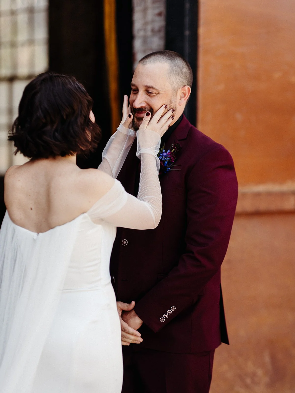 Wedding guest with a mohawk hairstyle, velvet blazer, and patterned neck scarf mingles during an alternative-inspired wedding cocktail hour.