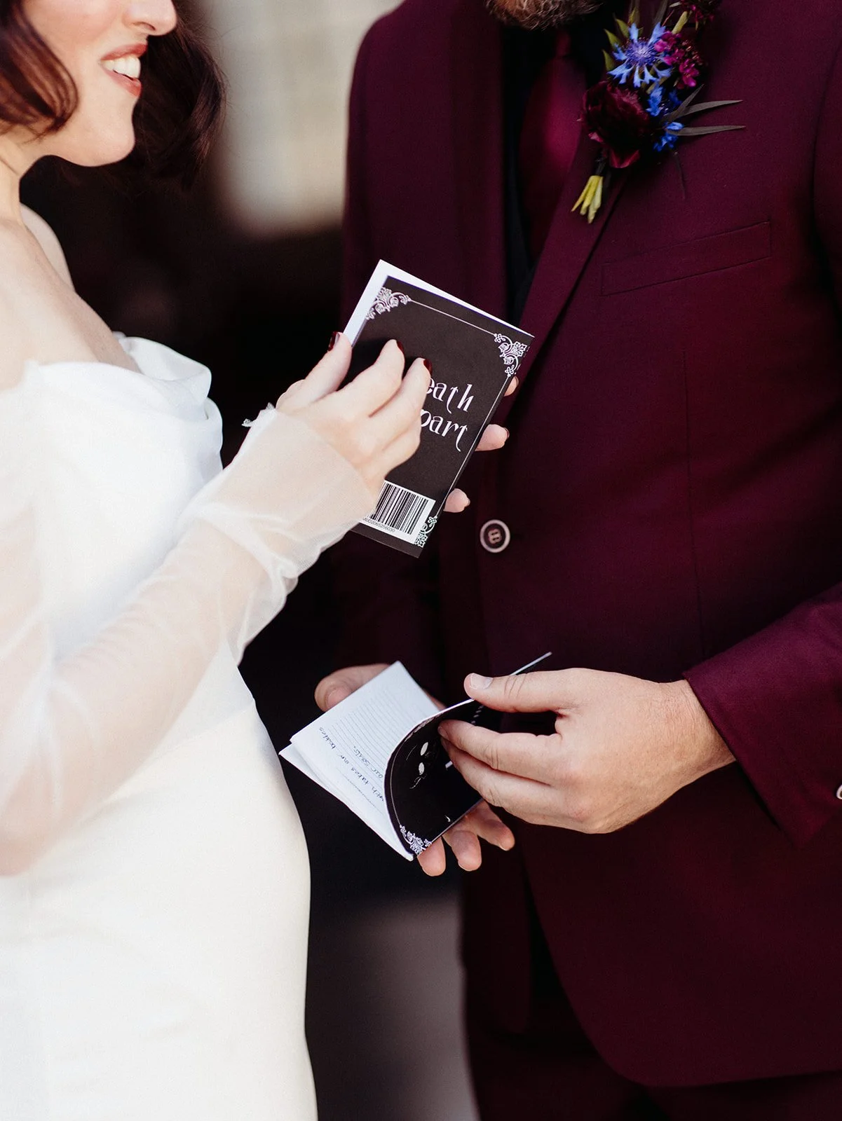 Bride and groom exchange personal vow books during their private first look, featuring custom black vow book covers and handwritten promises.