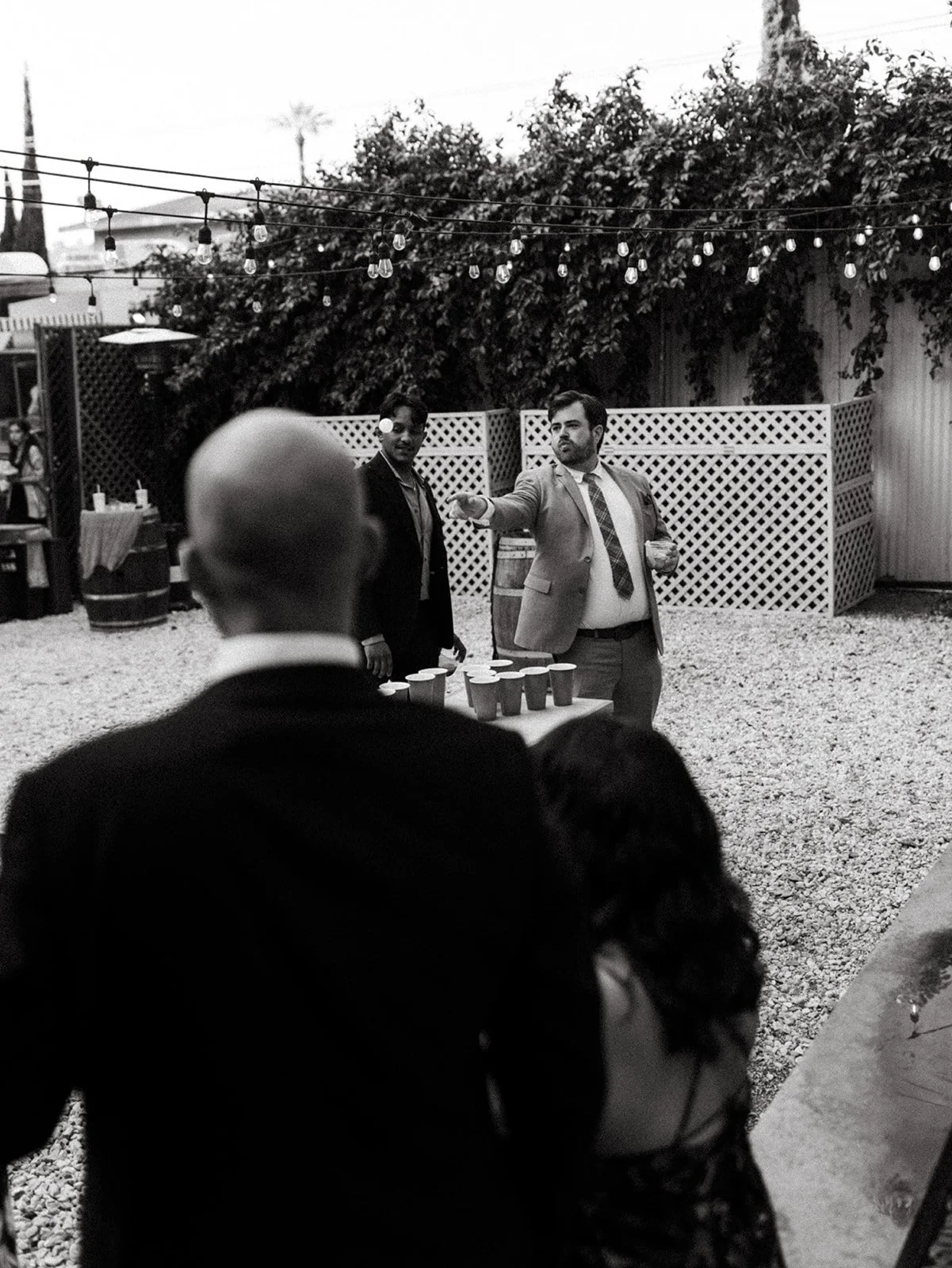 Wedding guests playing beer pong during outdoor cocktail hour, highlighting interactive games and a relaxed guest experience at a personalized wedding reception.