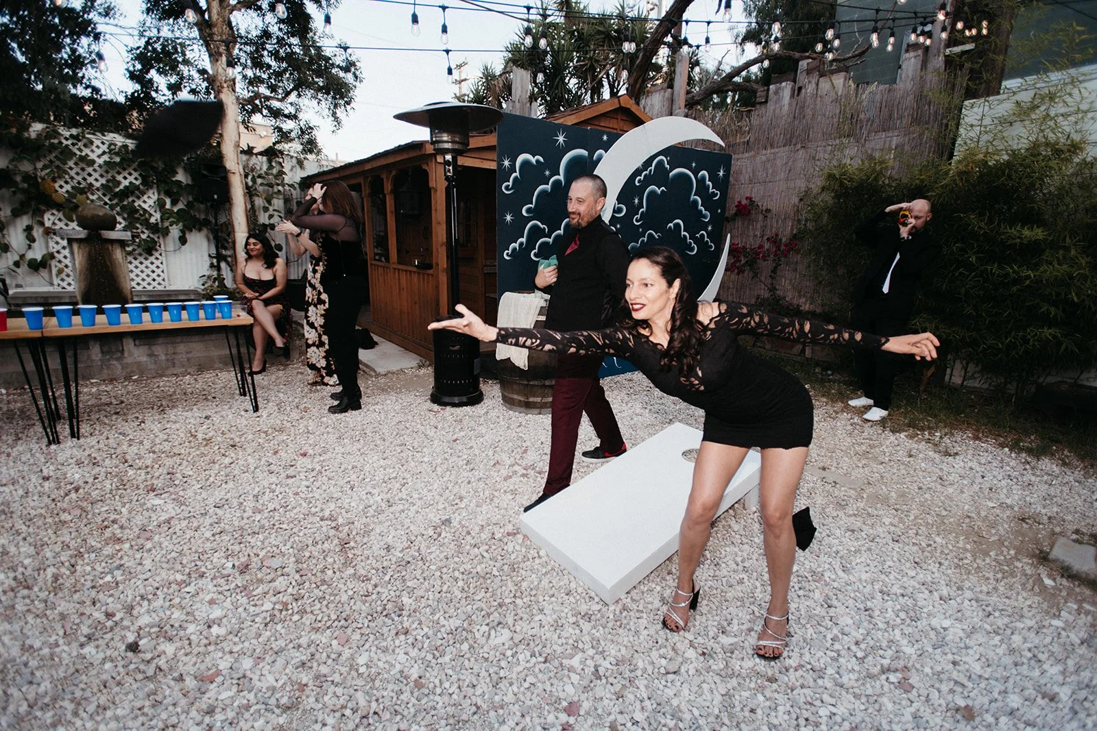 Wedding guests enjoying a cornhole tournament during the reception, showcasing personalized entertainment and guest-focused wedding experiences.