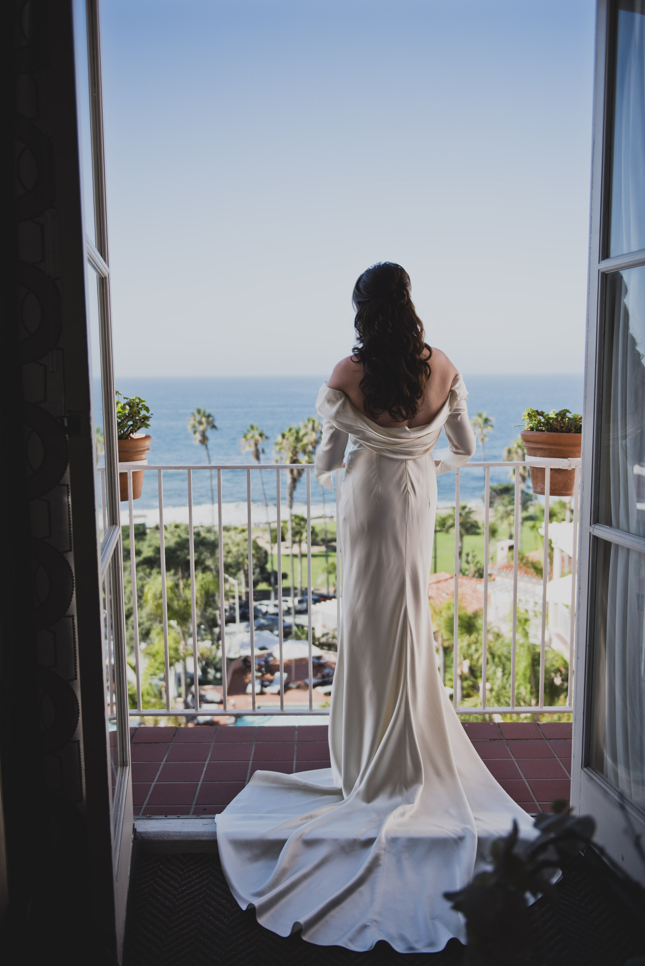 Bride overlooking the ocean from her balcony before the ceremony during a luxury destination wedding weekend.
