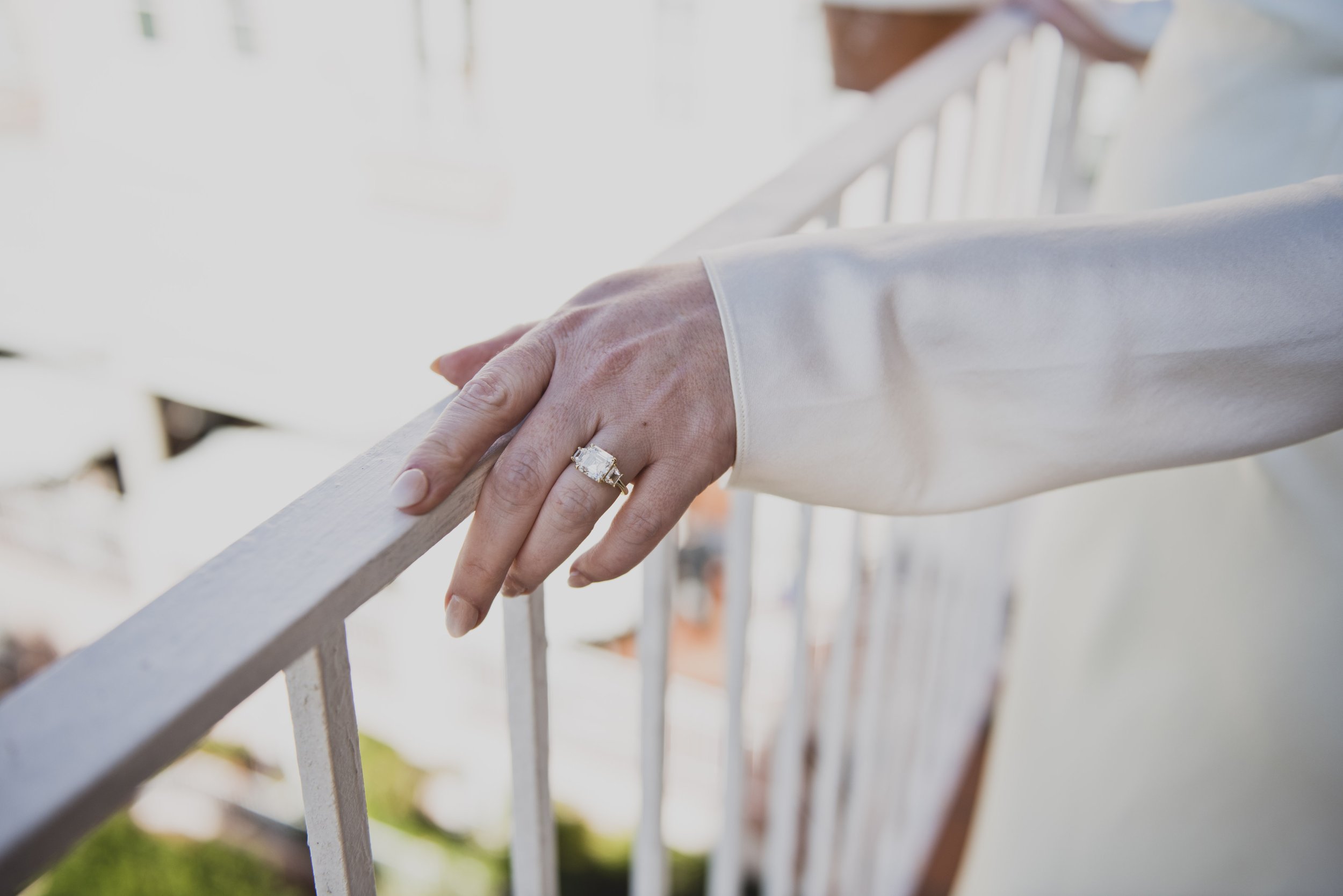 Close-up of the bride's engagement ring resting on a balcony railing before the destination wedding ceremony.