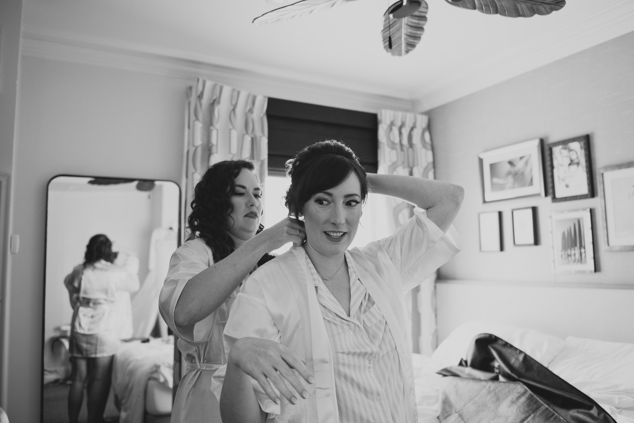 Bride getting ready with a bridesmaid before her luxury destination wedding, sharing a quiet moment before the ceremony.