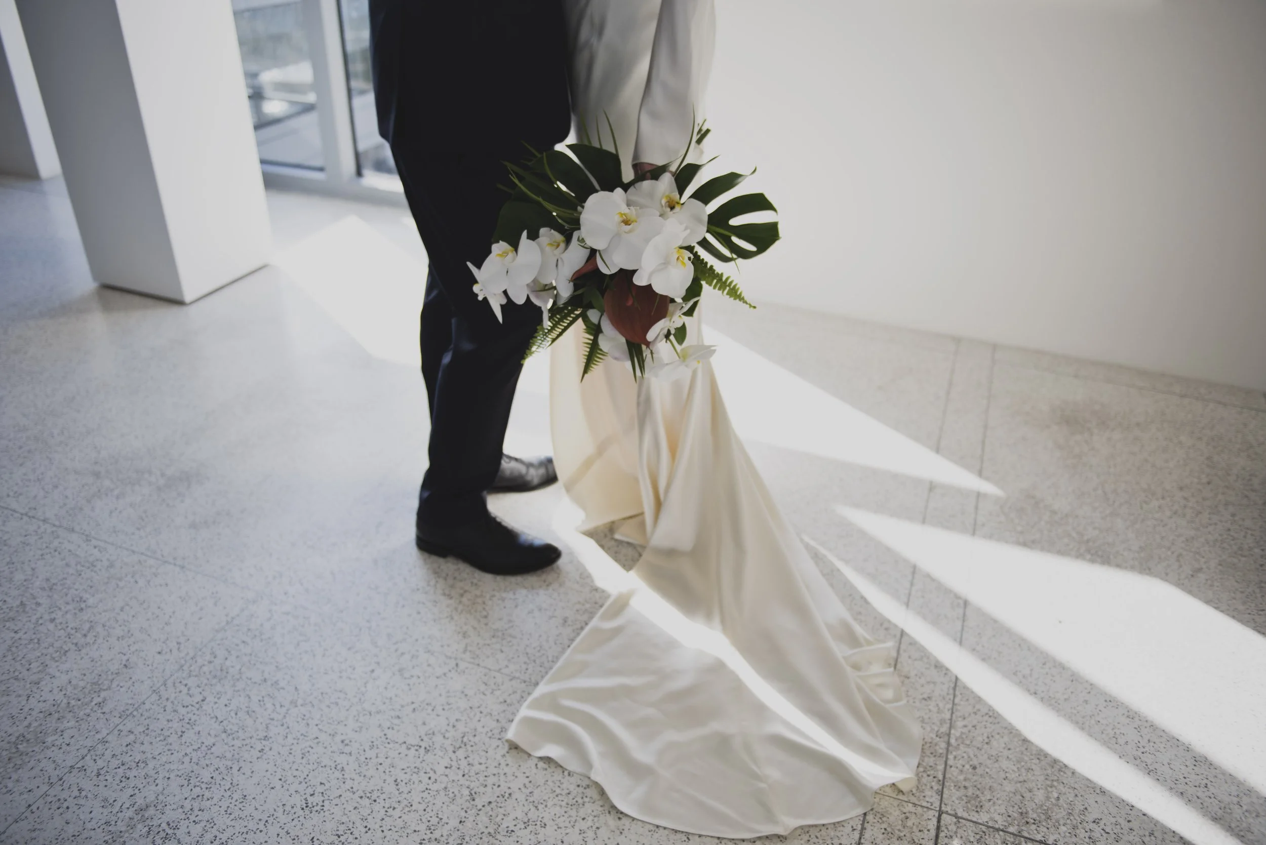 Modern bridal bouquet with white orchids and tropical greenery during a luxury destination wedding.