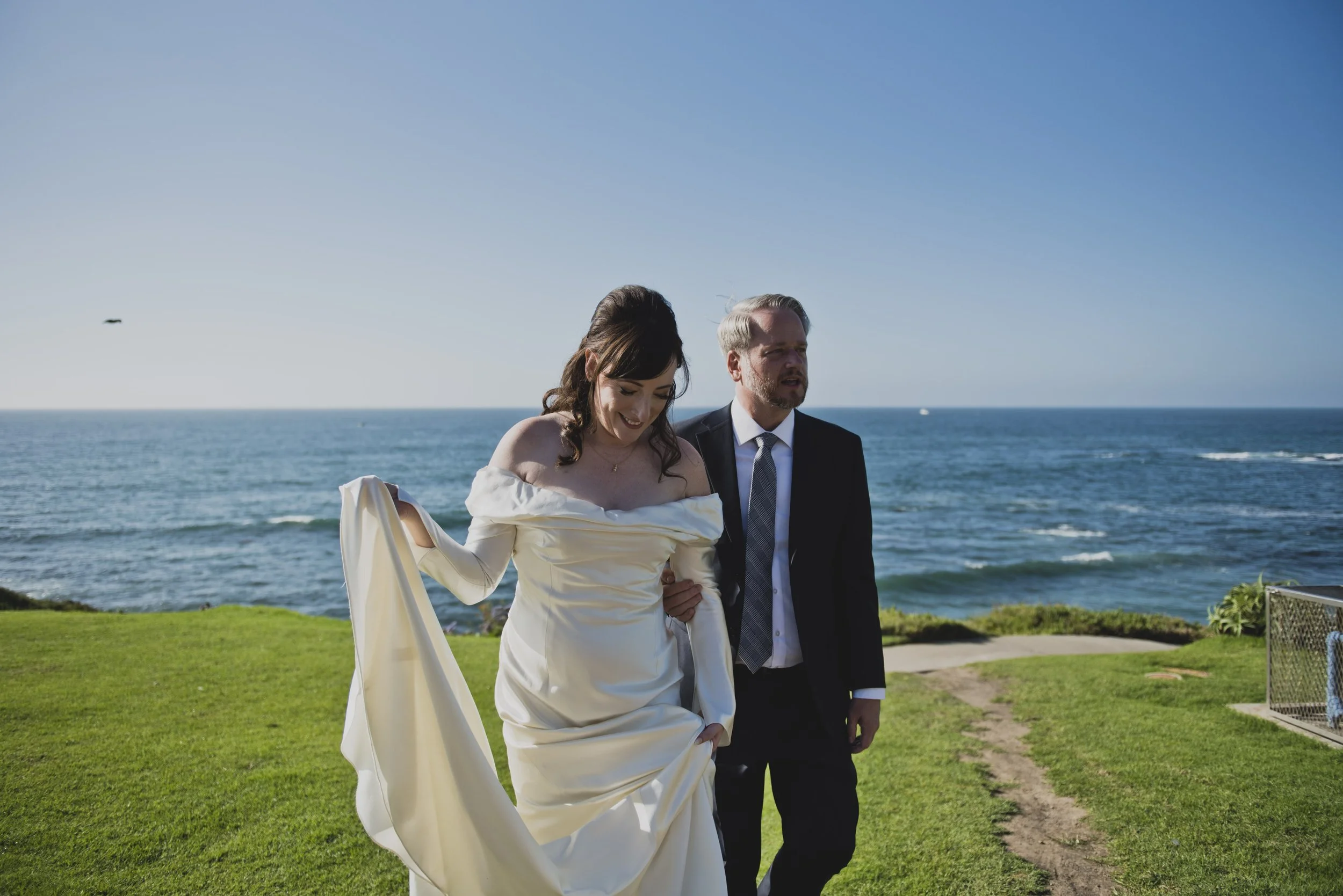 Bride and groom walking together along the oceanfront before their luxury destination wedding ceremony.