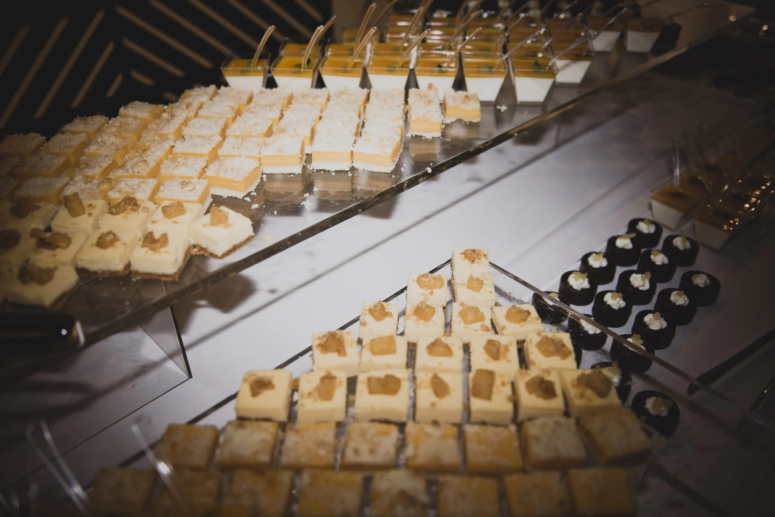 Elegant dessert display at a luxury destination wedding reception featuring an assortment of handcrafted mini desserts.