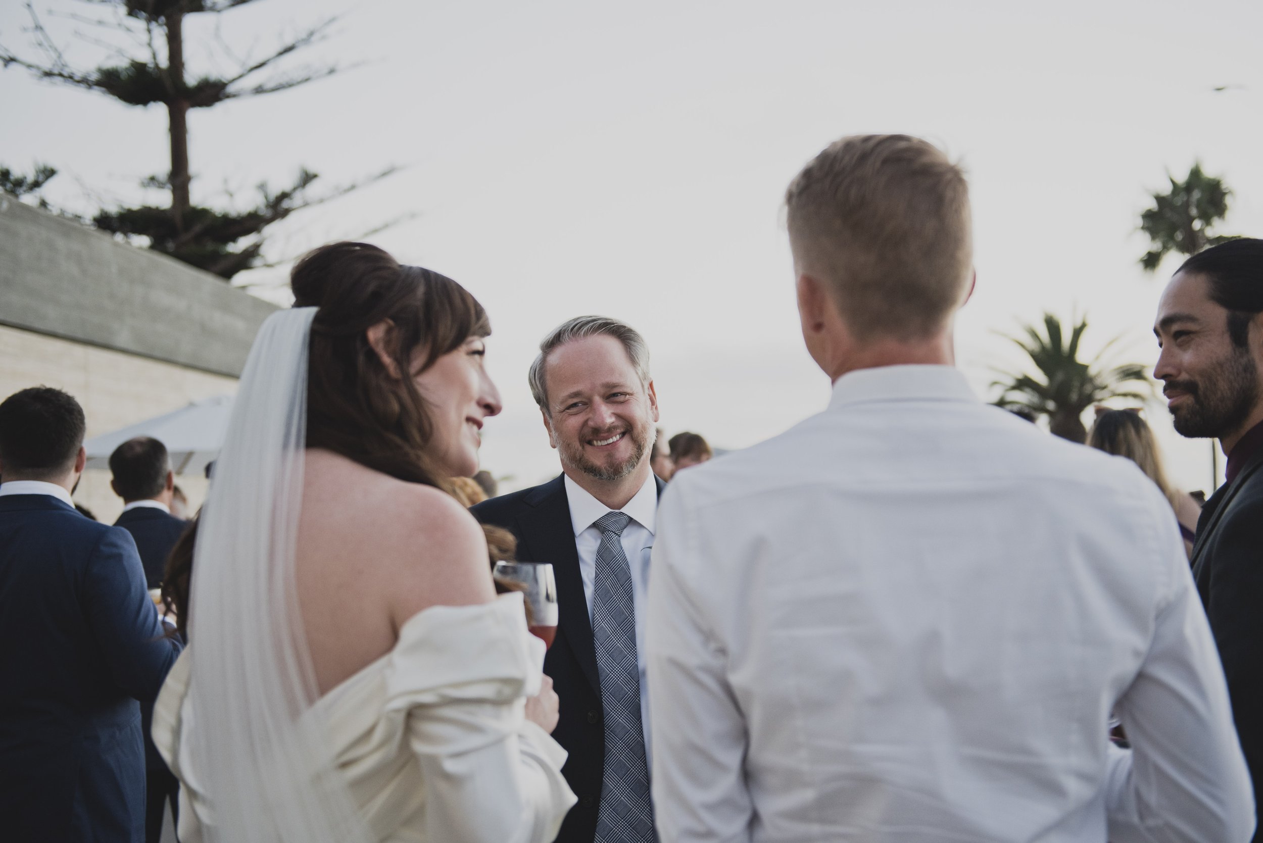 Bride and groom sharing a joyful moment beneath towering cacti before their destination wedding celebration.