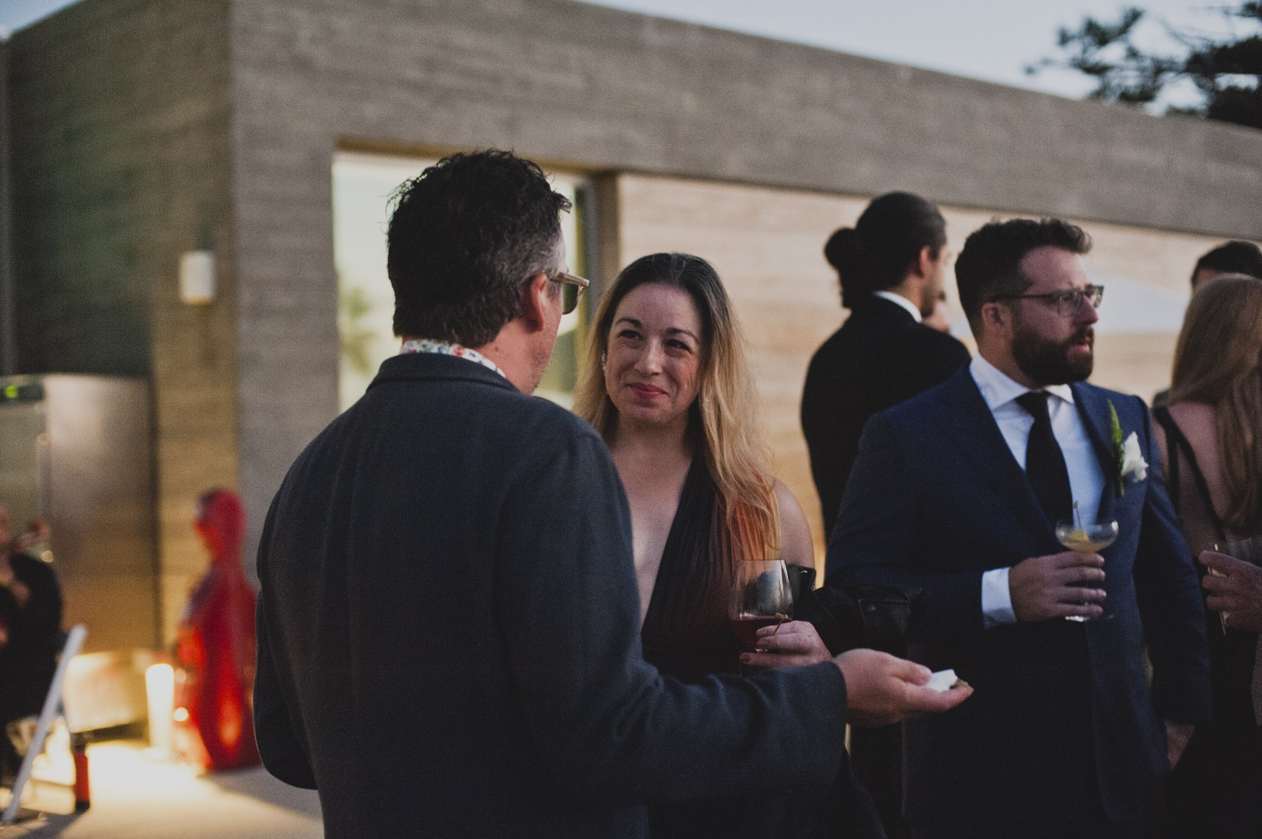 Wedding guests outside a modern art museum before an oceanfront wedding reception.
