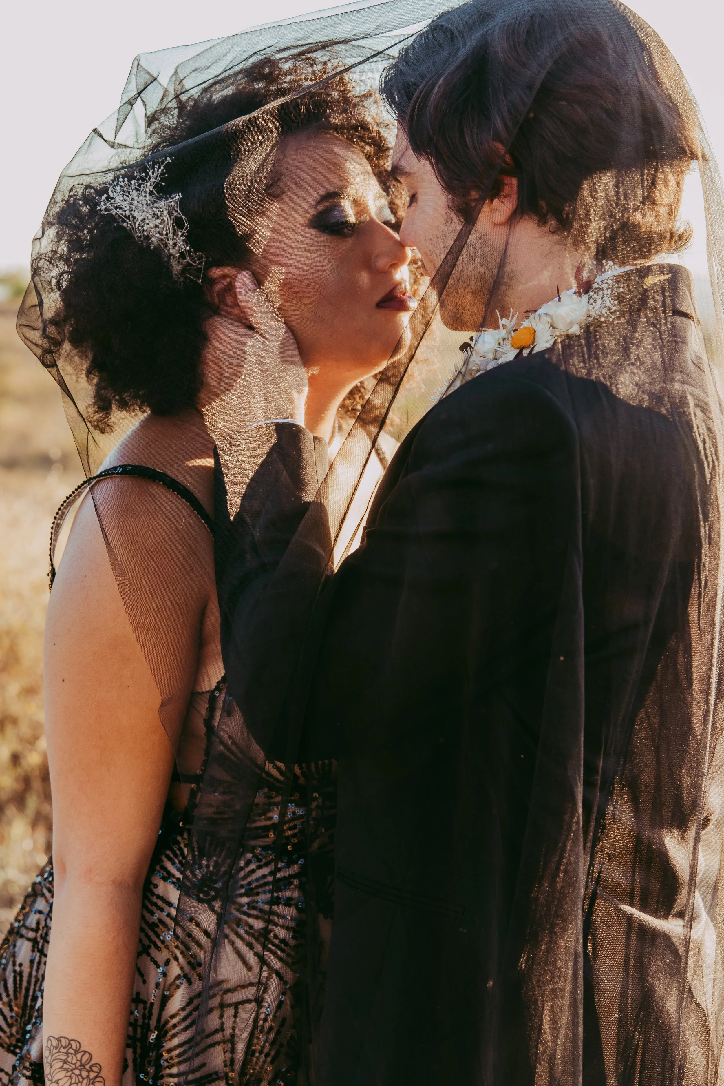 Dark suit and moody styling details on the groom at an alternative wedding
