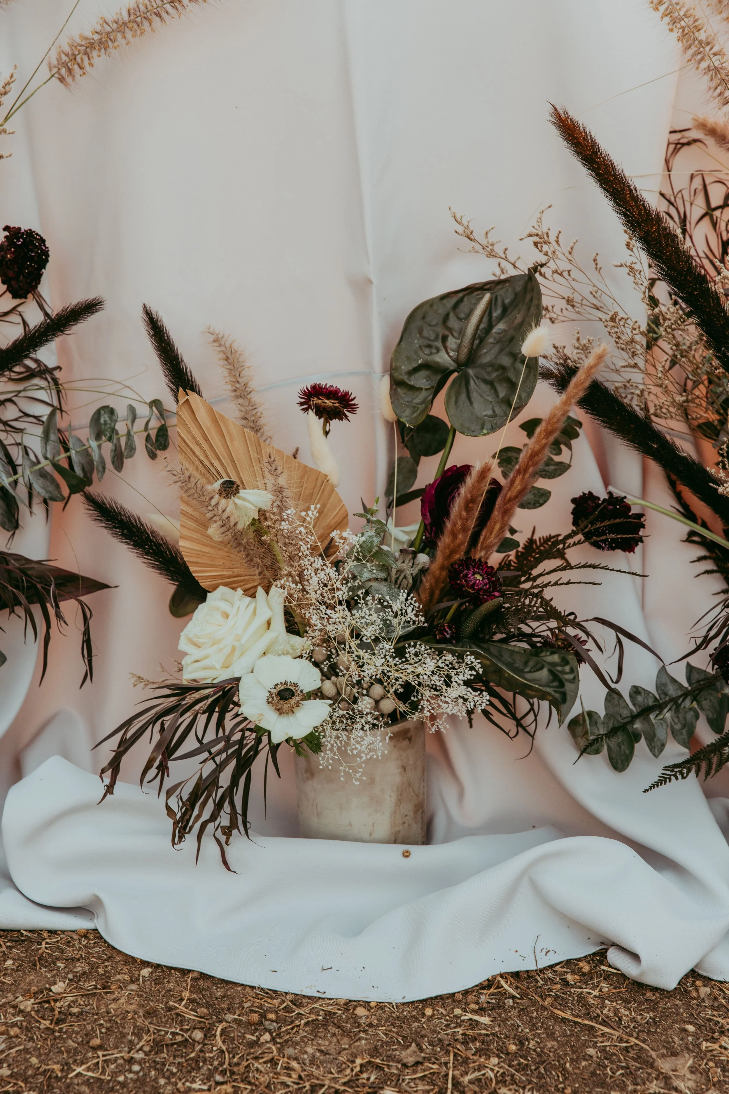 Dark and moody Lion King Scar wedding tablescape with dried florals and stone-toned linens