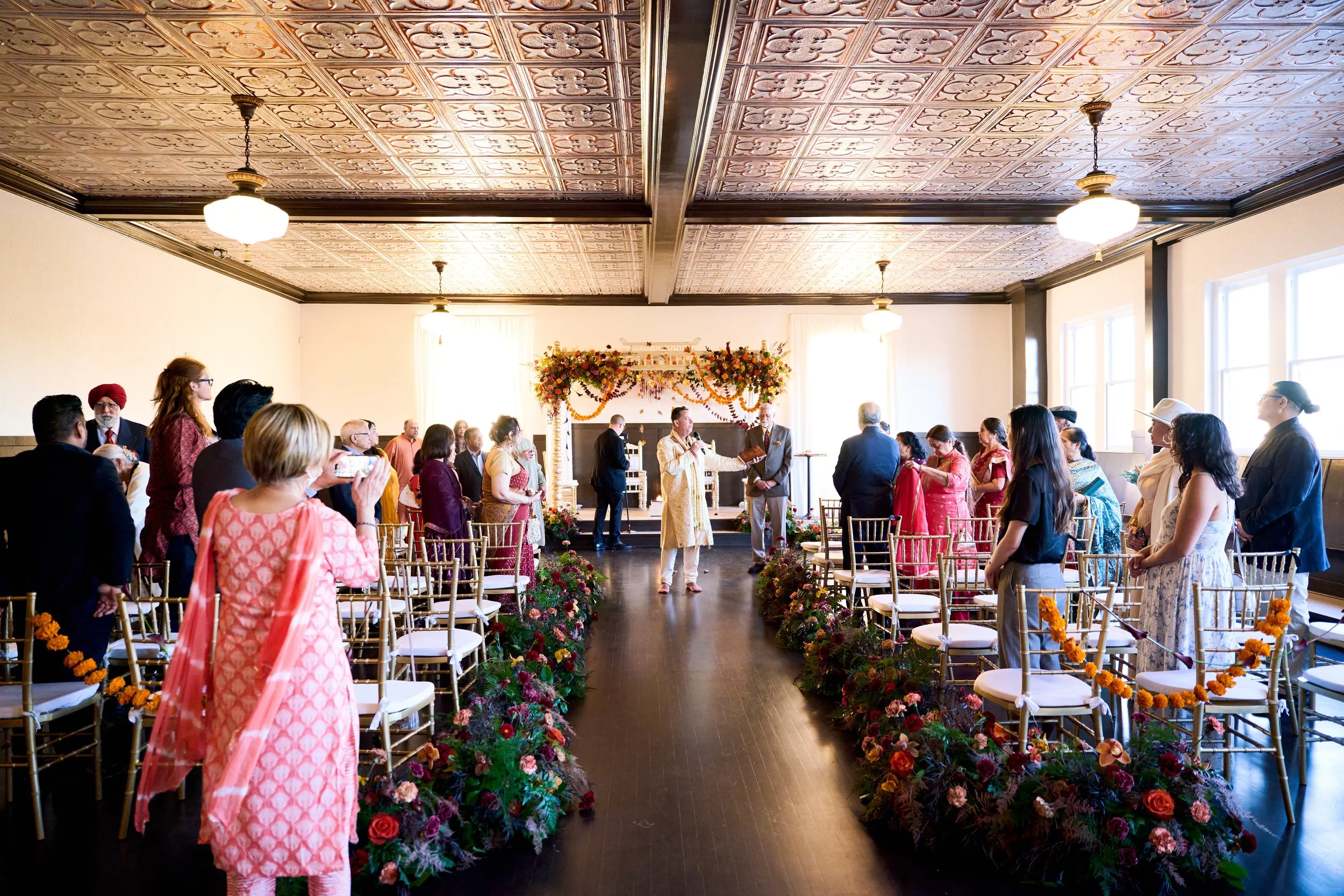 Guests dancing to a dhol drum during the baraat at an Indian wedding