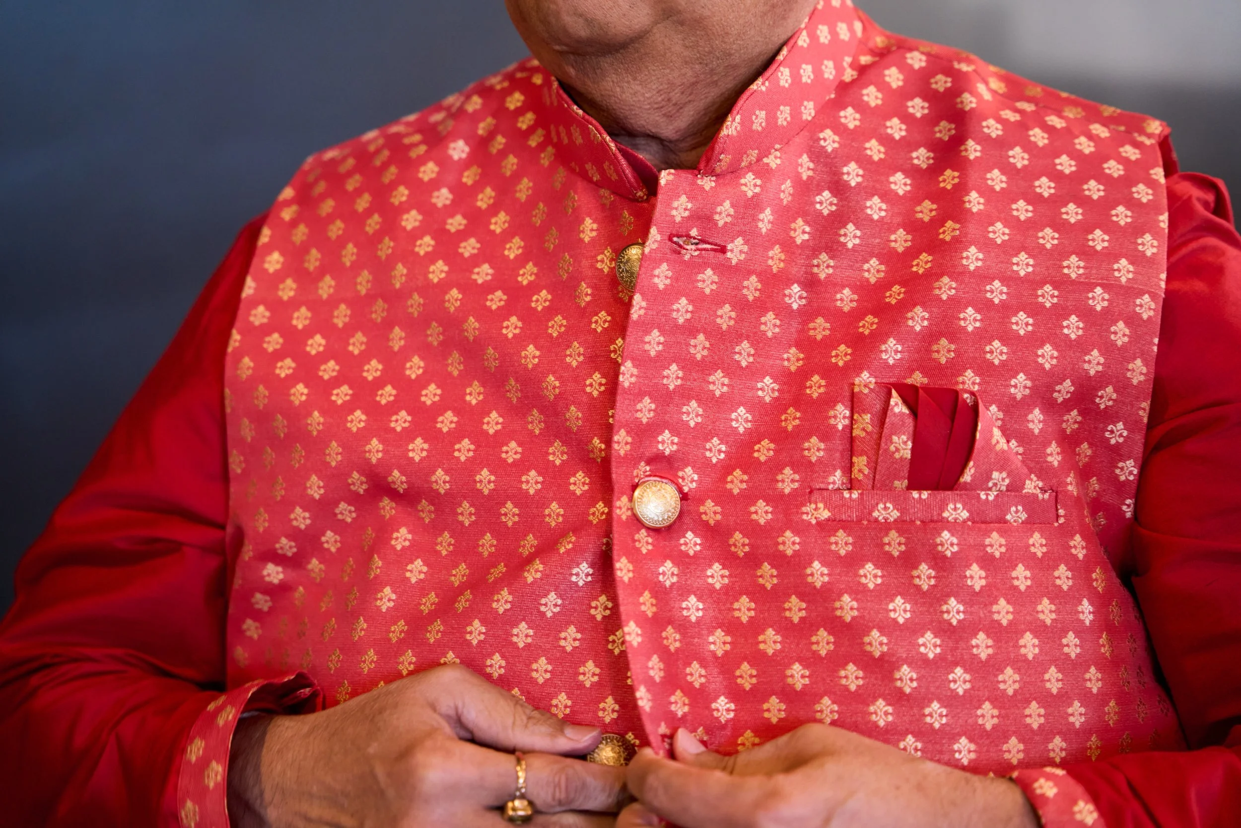 Groom buttoning his traditional Hindu wedding attire